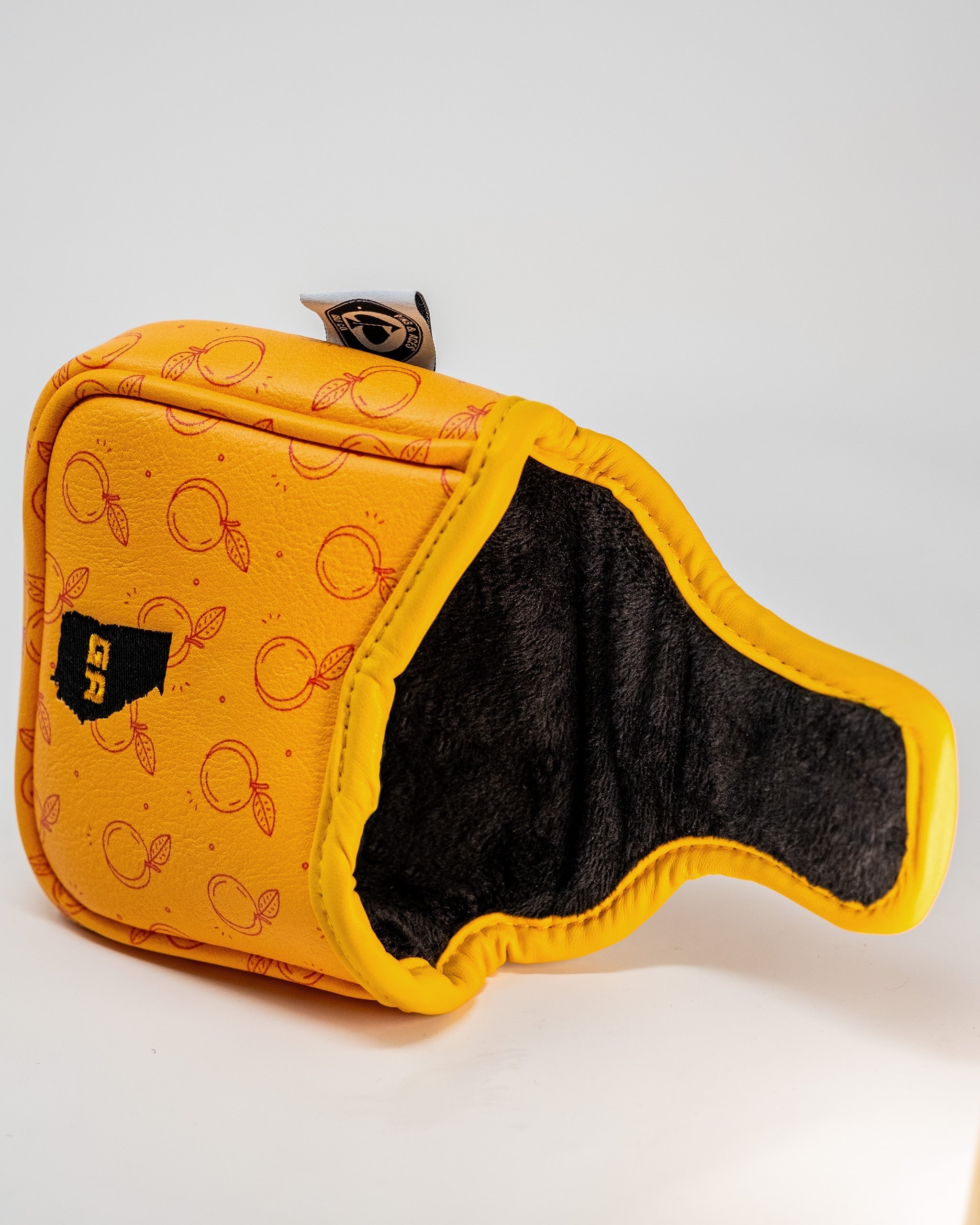 Bright yellow mallet cover featuring a playful orange pattern, designed to protect golf putters with style.