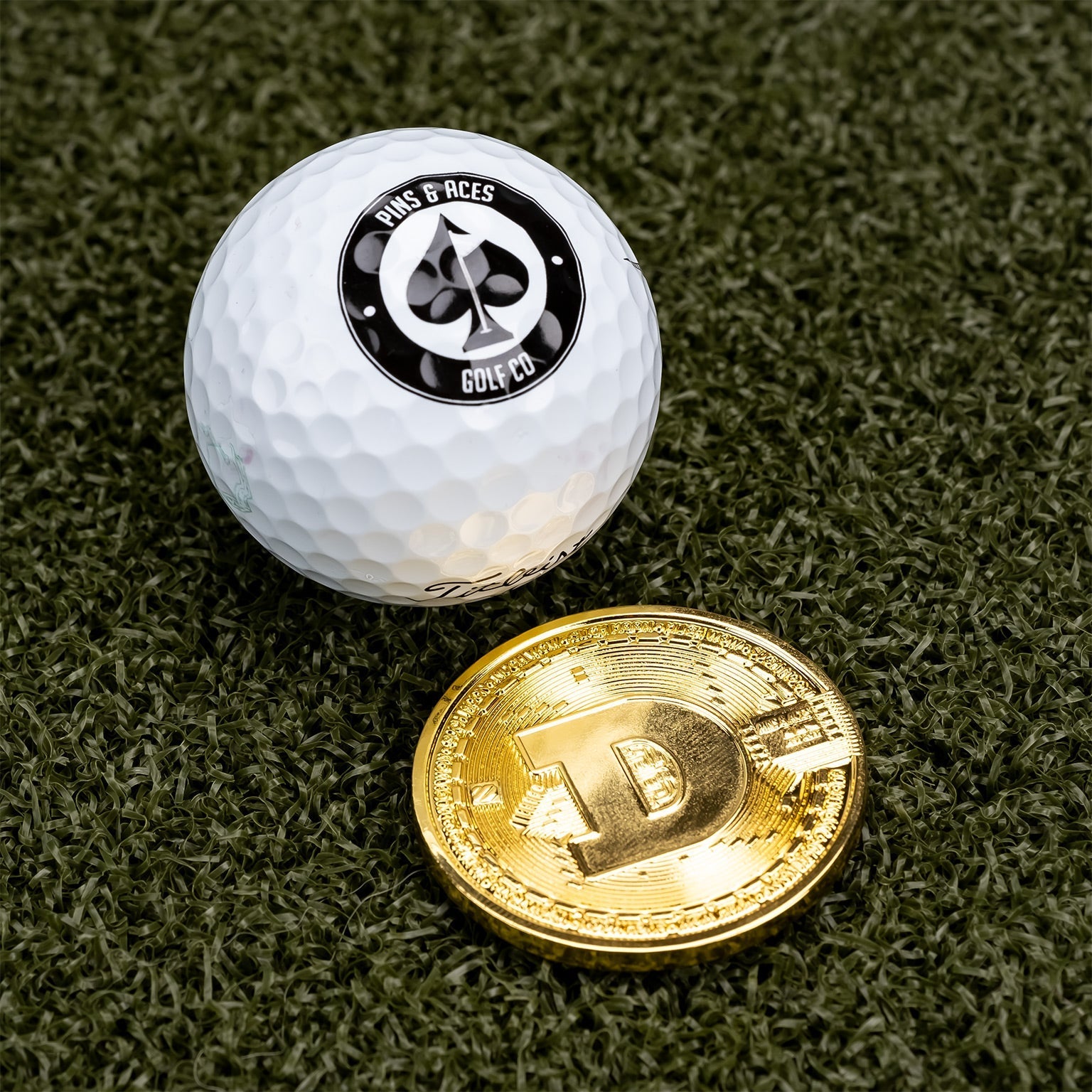 Dogecoin ball marker next to a golf ball, featuring a bold design for stylish golfing accessories.