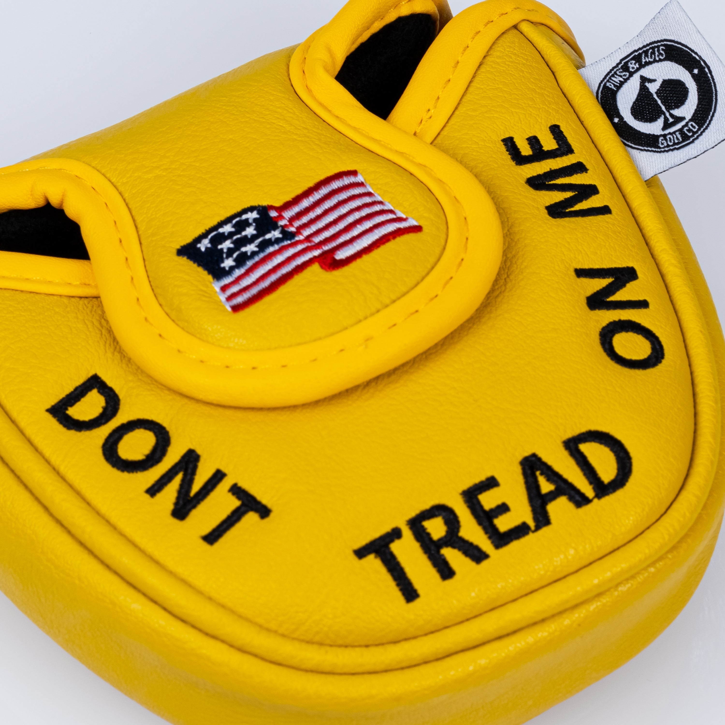 Yellow mallet putter cover featuring "Don't Tread on Me" text and an American flag design, perfect for bold golfers.