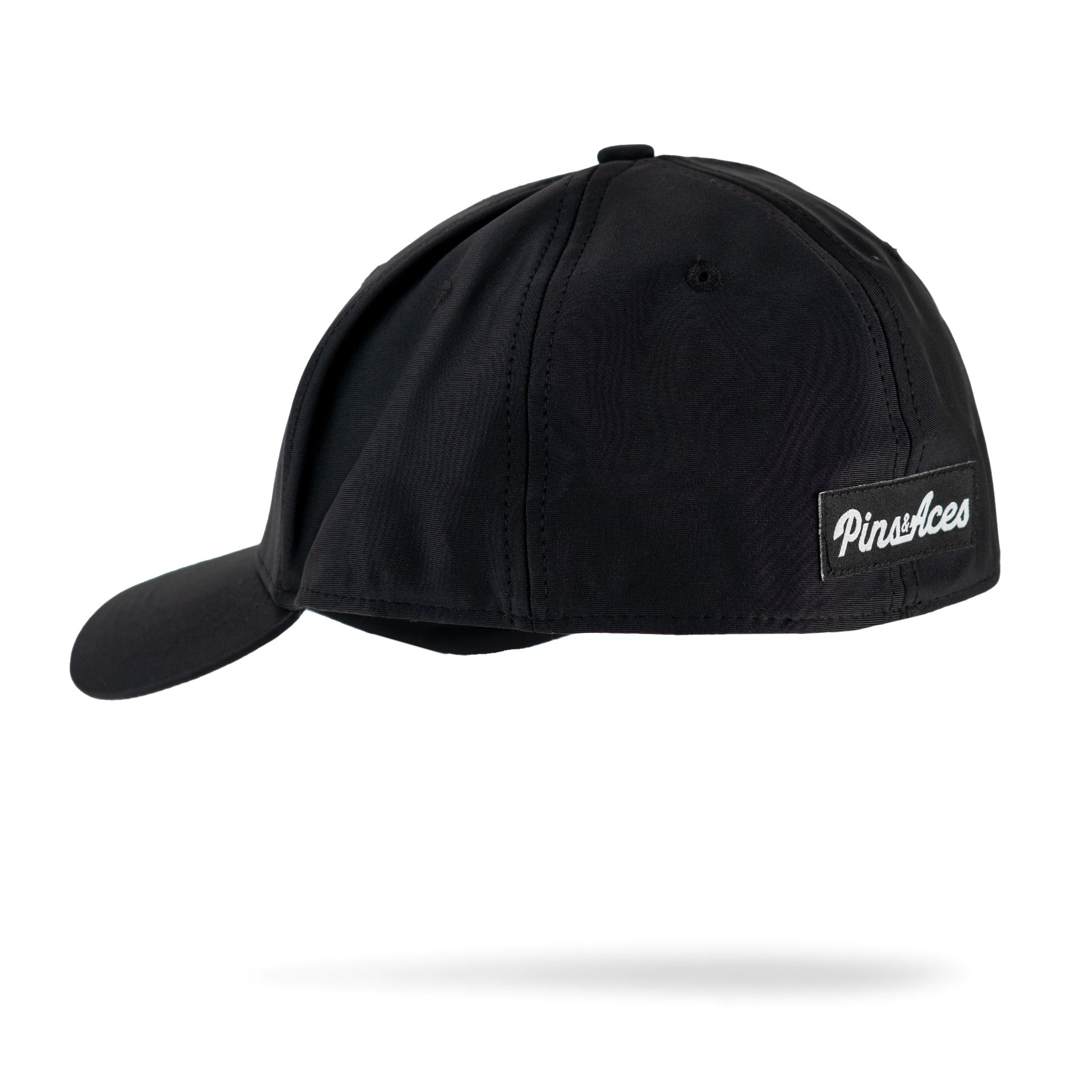 Fitted black performance hat with a sleek design and Pins Aces logo on the side, ideal for stylish golfers.