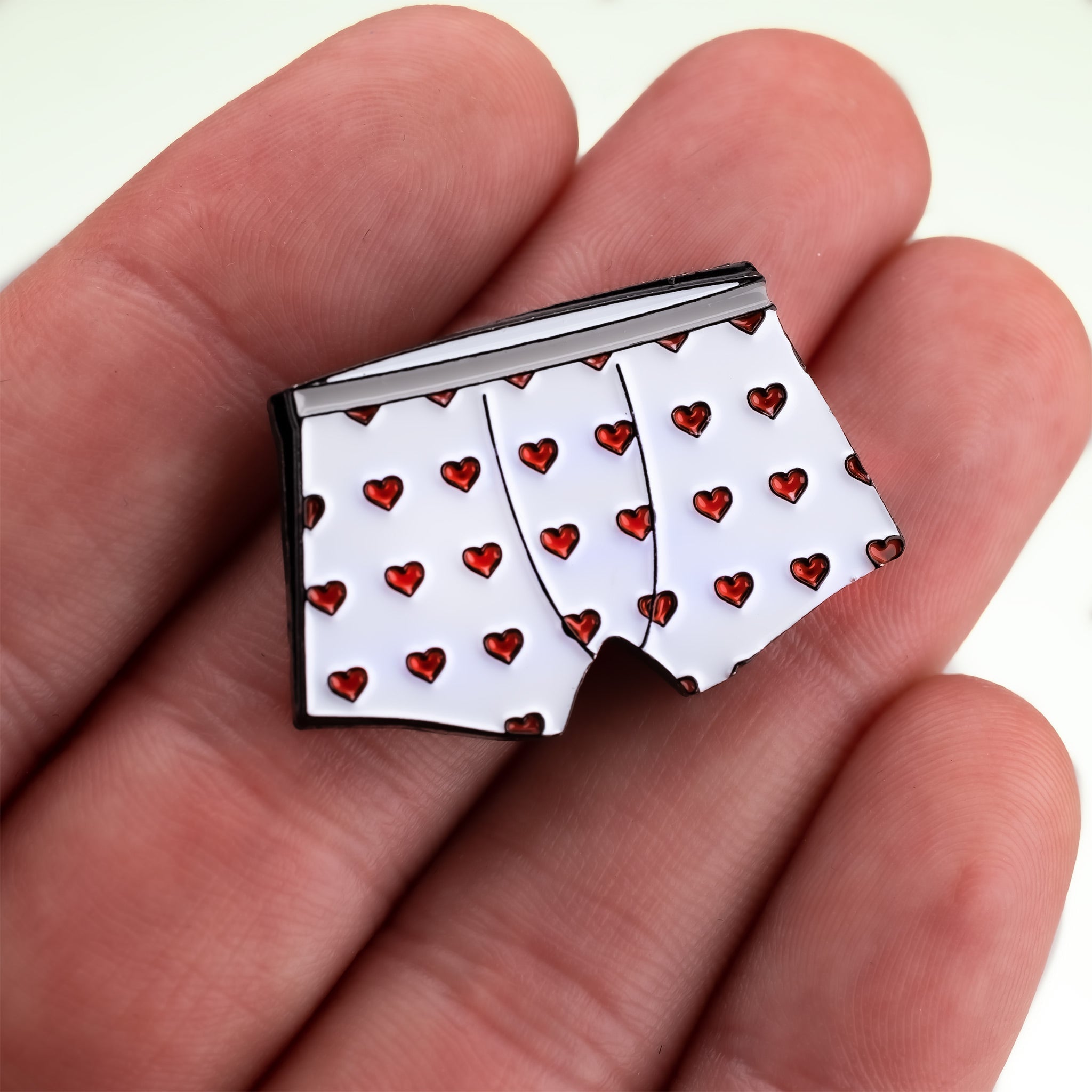Heart Boxers Ball Marker featuring a playful design of white boxers adorned with red hearts, perfect for adding flair to your golf game.