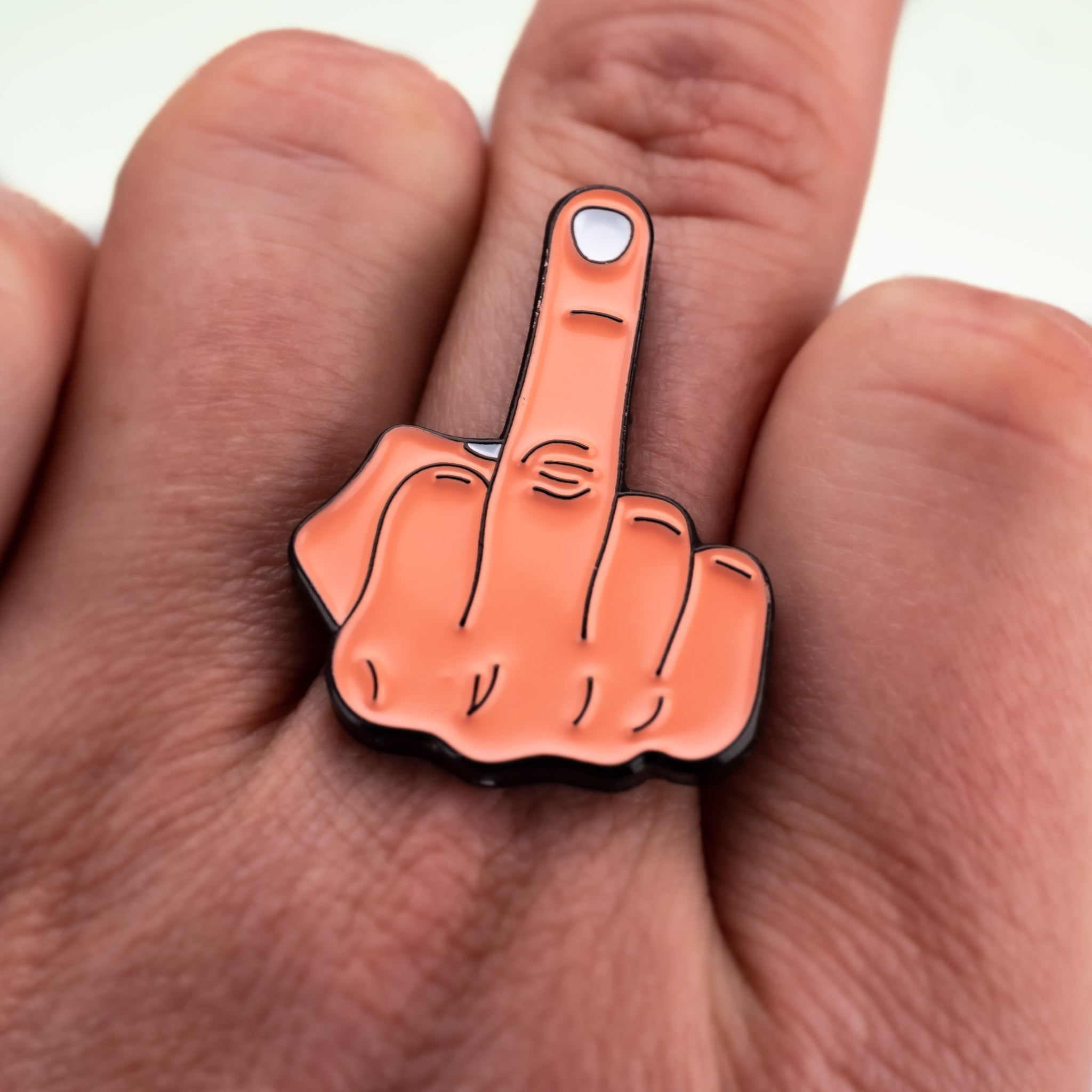 Middle finger ball marker displayed on a hand, featuring a bold design that adds humor to the golf experience.