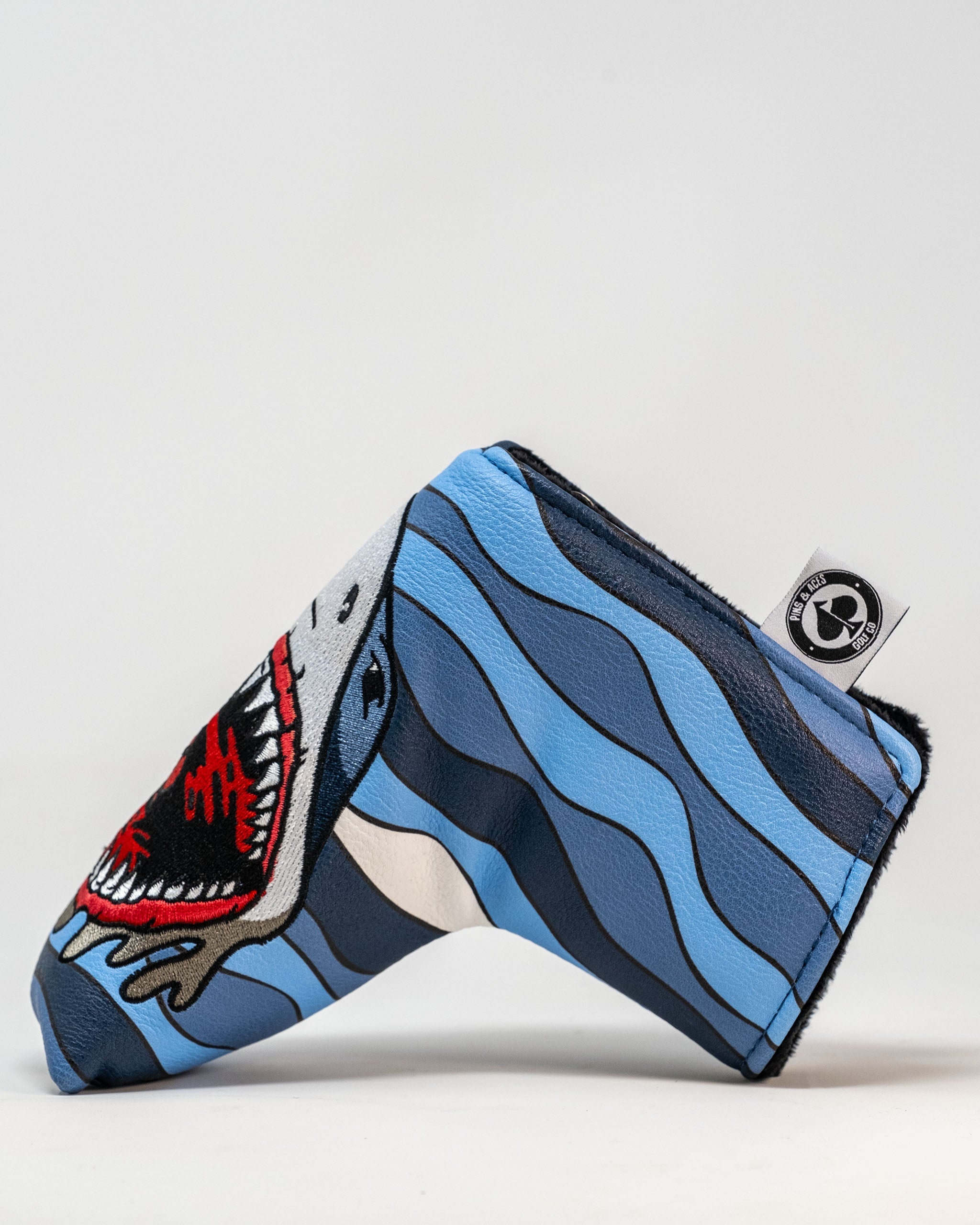 Bold Shark Attack blade putter cover featuring a fierce shark design against a blue wave background, perfect for standout golfers.