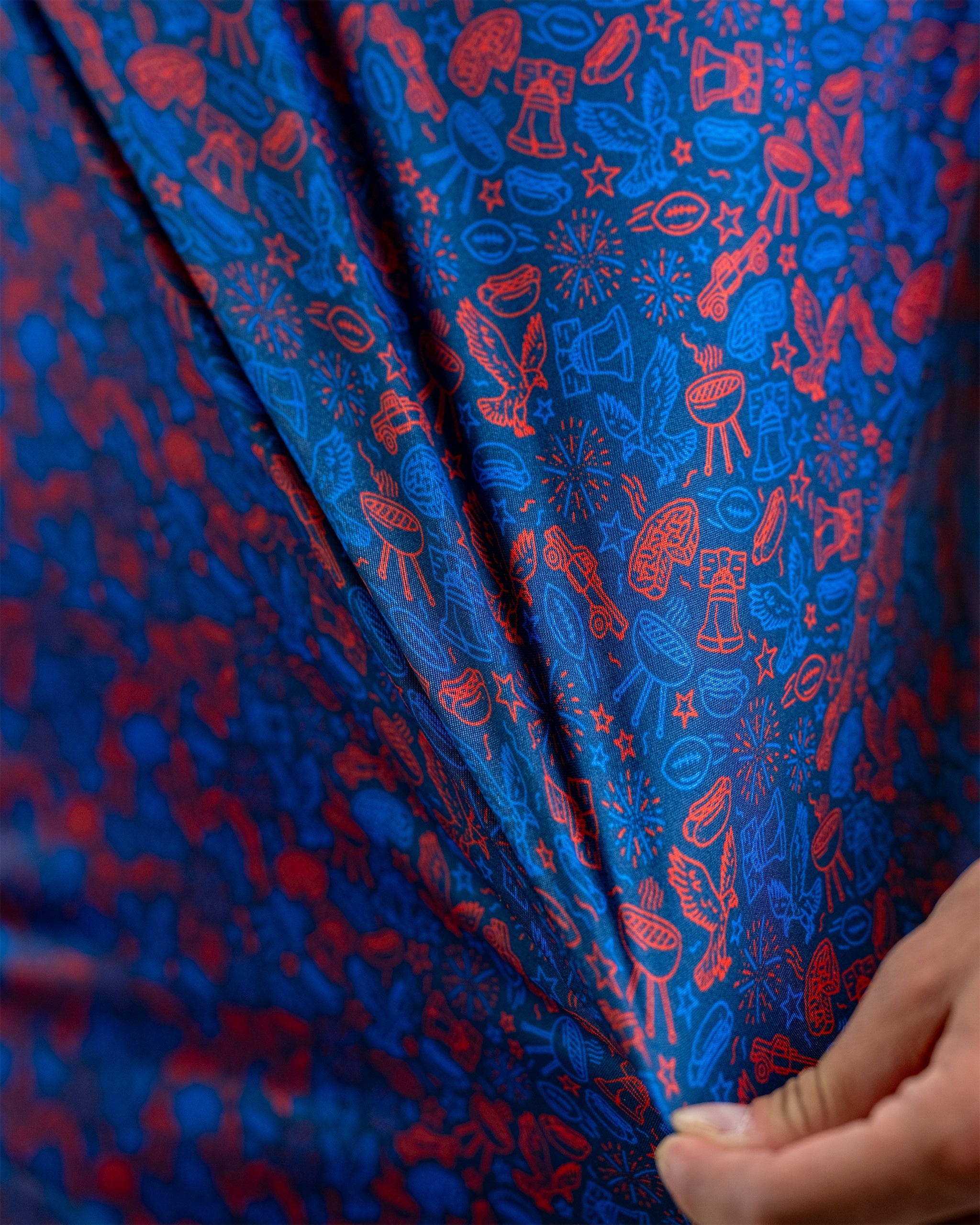 Navy fabric featuring a playful red doodle pattern of sports and celebration icons, ideal for bold golf apparel.