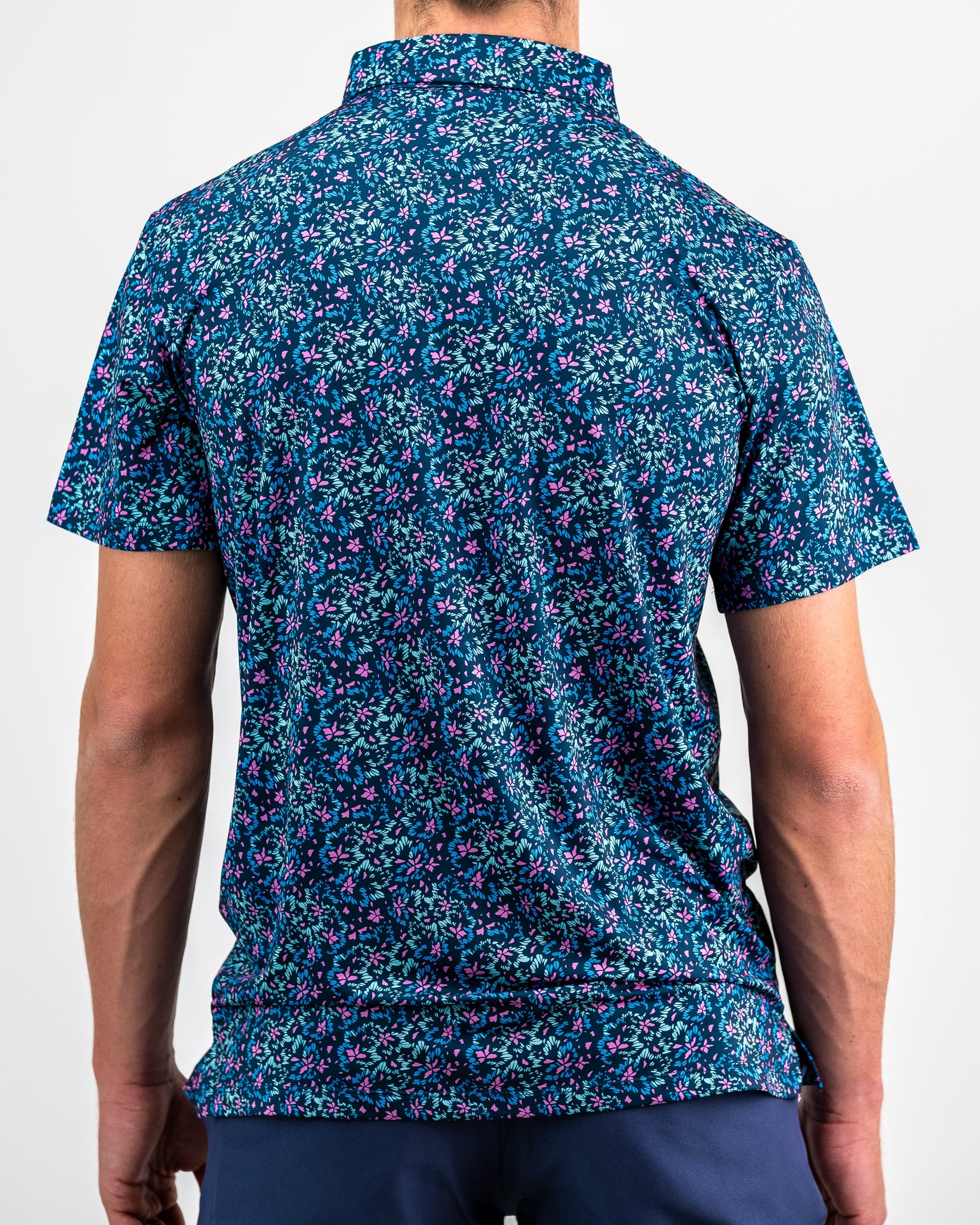 Fluorescent floral dress with vibrant colors and a modern design, showcased on a model outdoors.