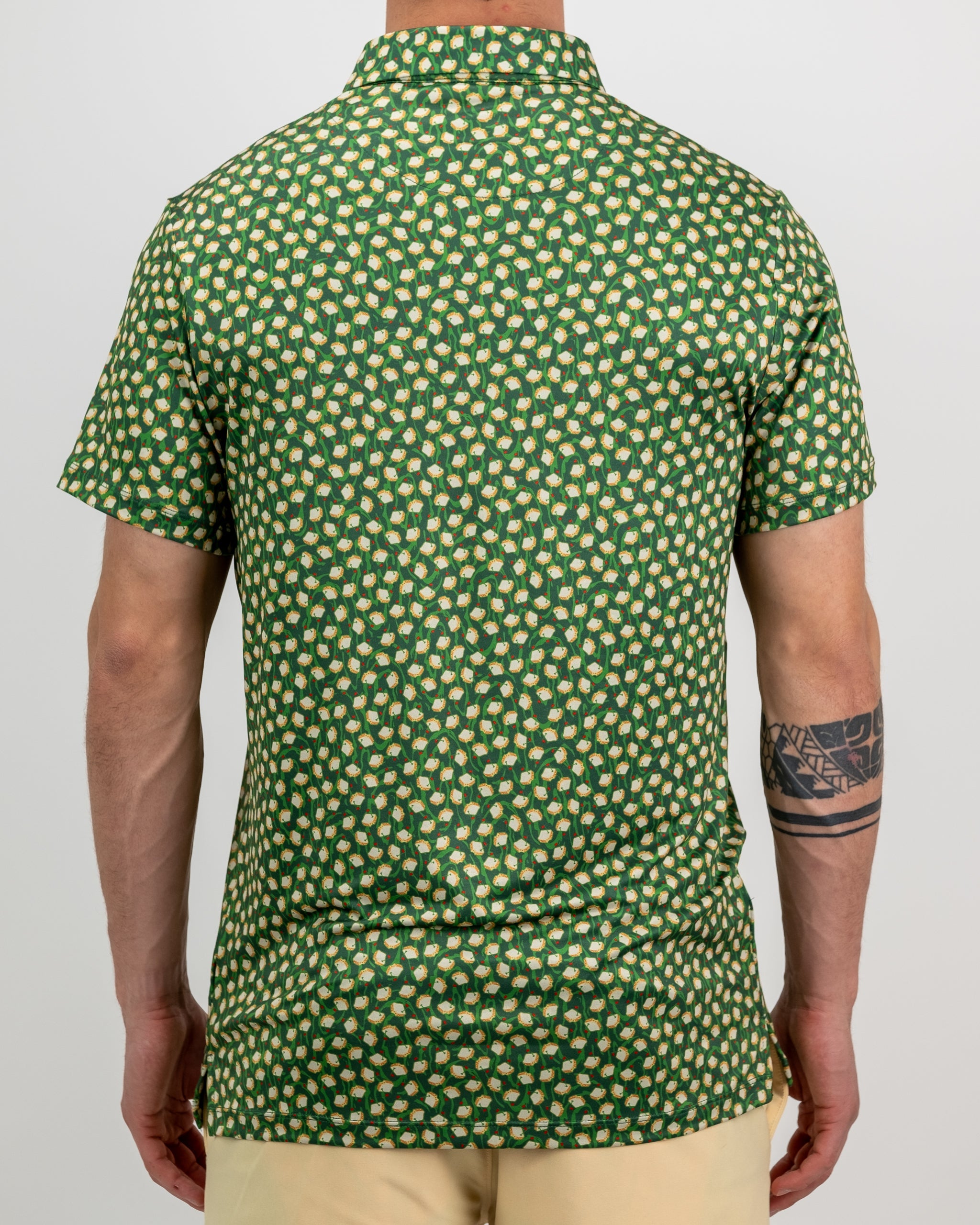 Green golf shirt with a bold, repeating pattern of white golf balls and red tees, perfect for standing out on the course.