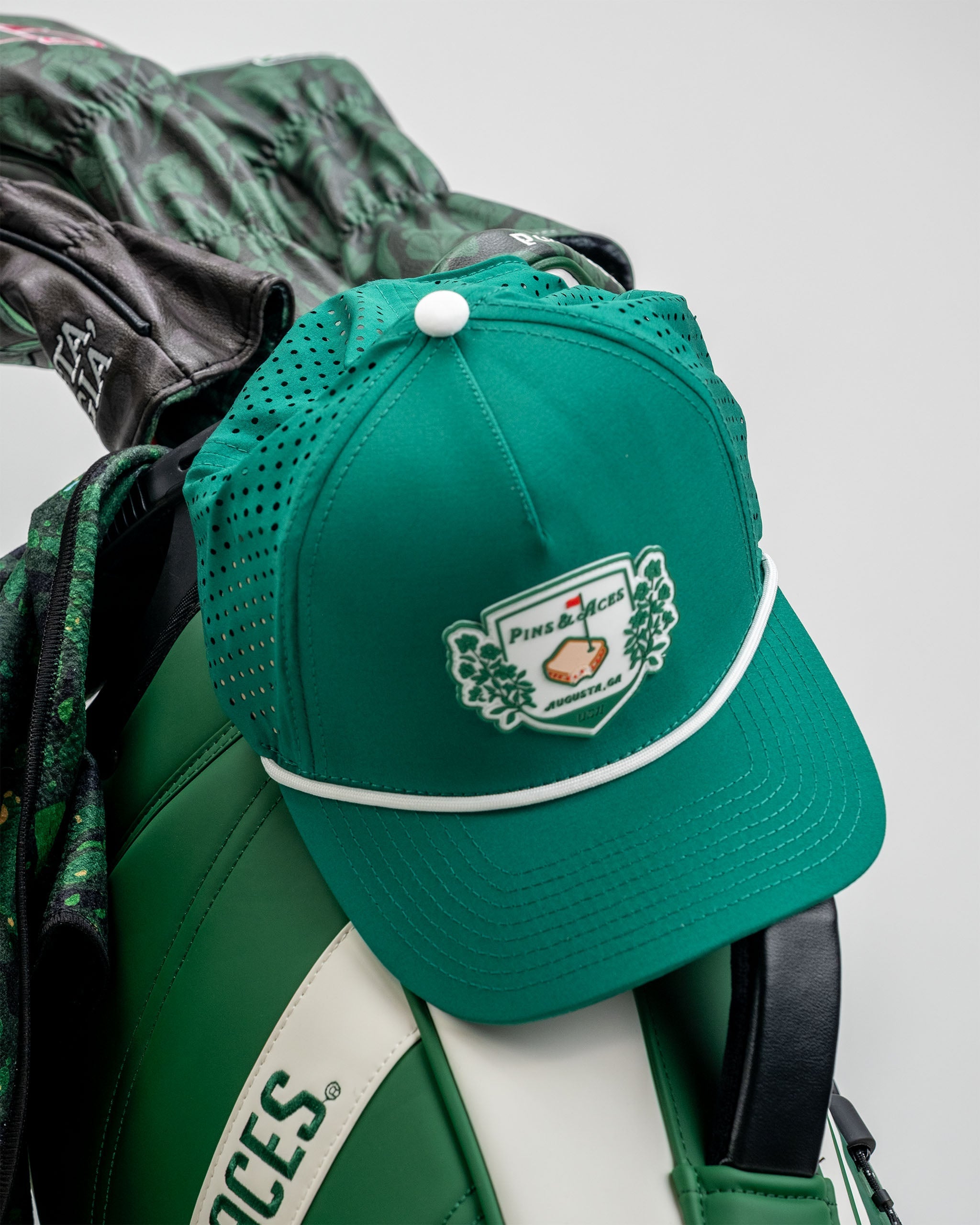 Green perforated rope hat by Pimento Crest, featuring a stylish design and adjustable strap.