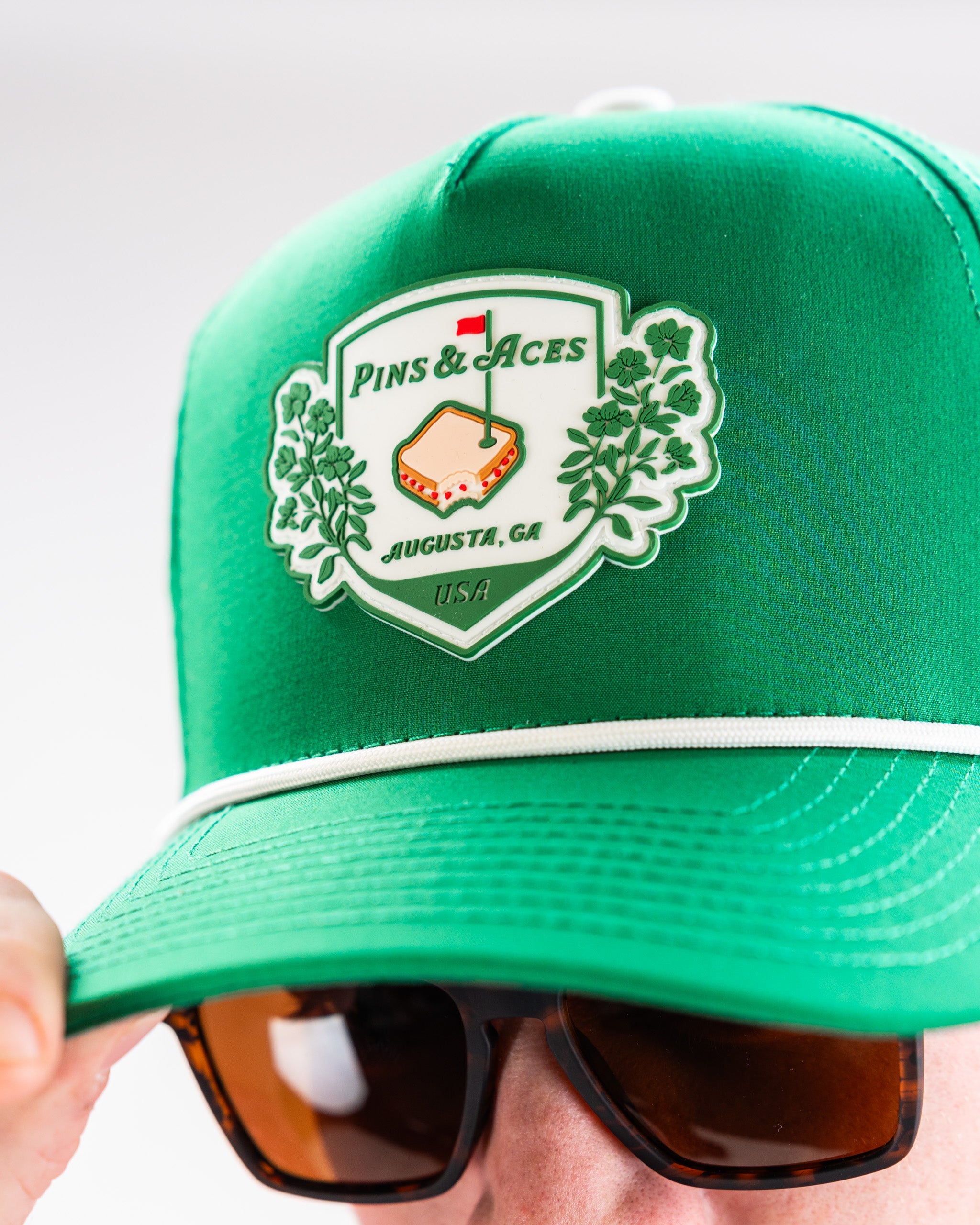 Green perforated rope hat with Pimento Crest logo.