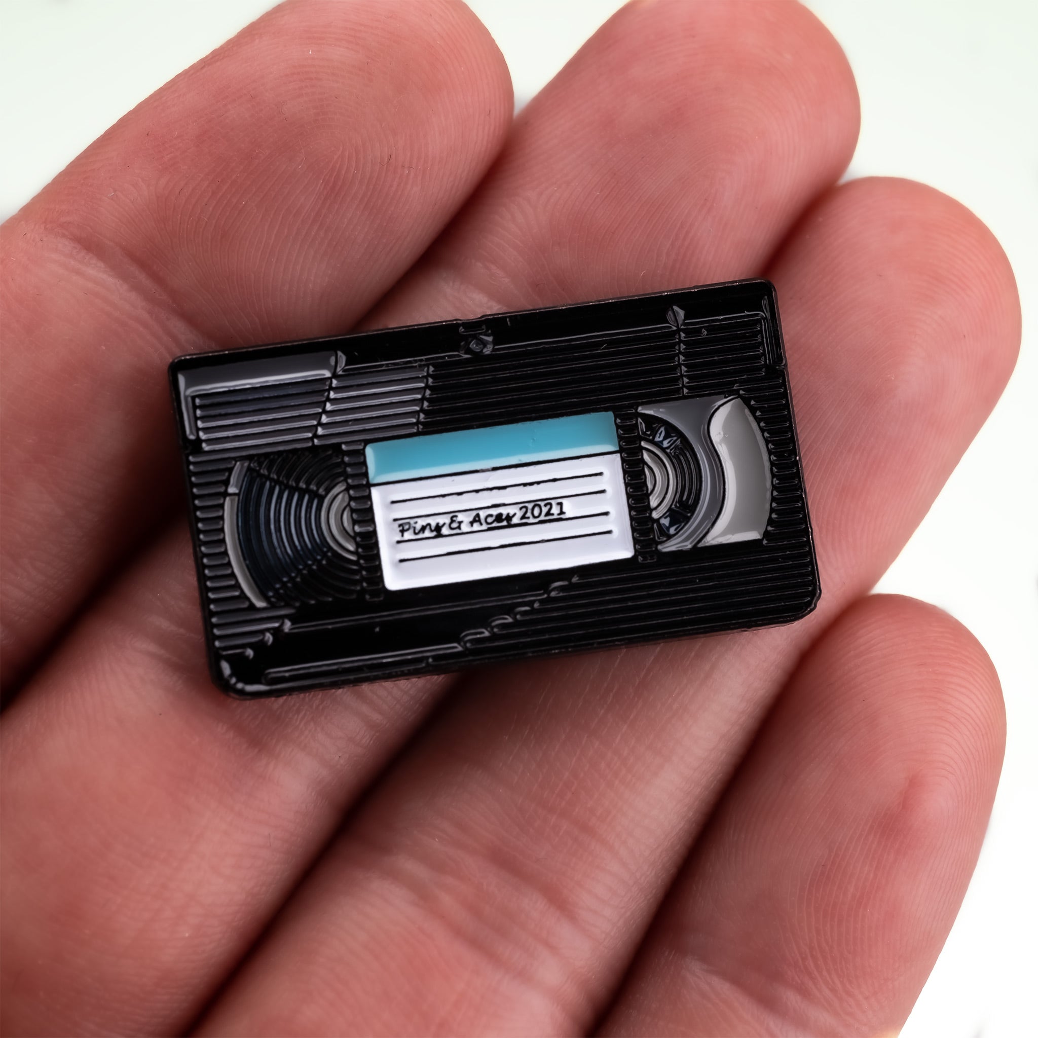 VHS ball marker held in hand, featuring a retro design with colorful details, ideal for golfers.