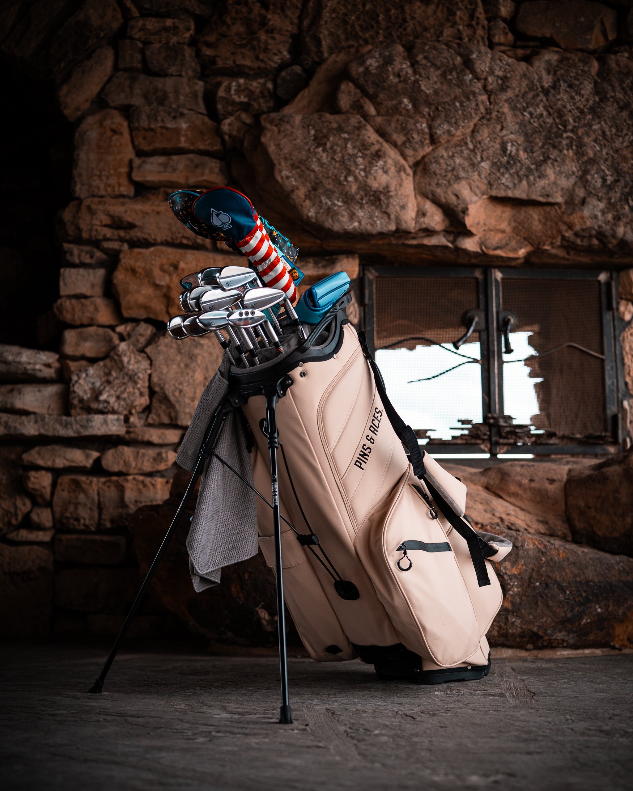 Golf club bag with clubs, headcovers, and accessories in a rustic indoor setting, highlighting bold, unique golf gear.