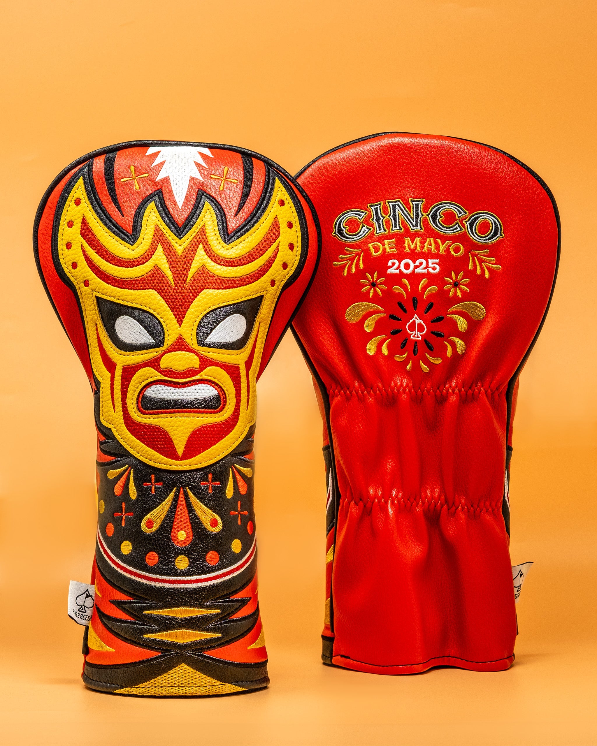Colorful lucha libre mask-themed driver cover with vibrant red, yellow, and black embroidery, celebrating Cinco de Mayo 2025.