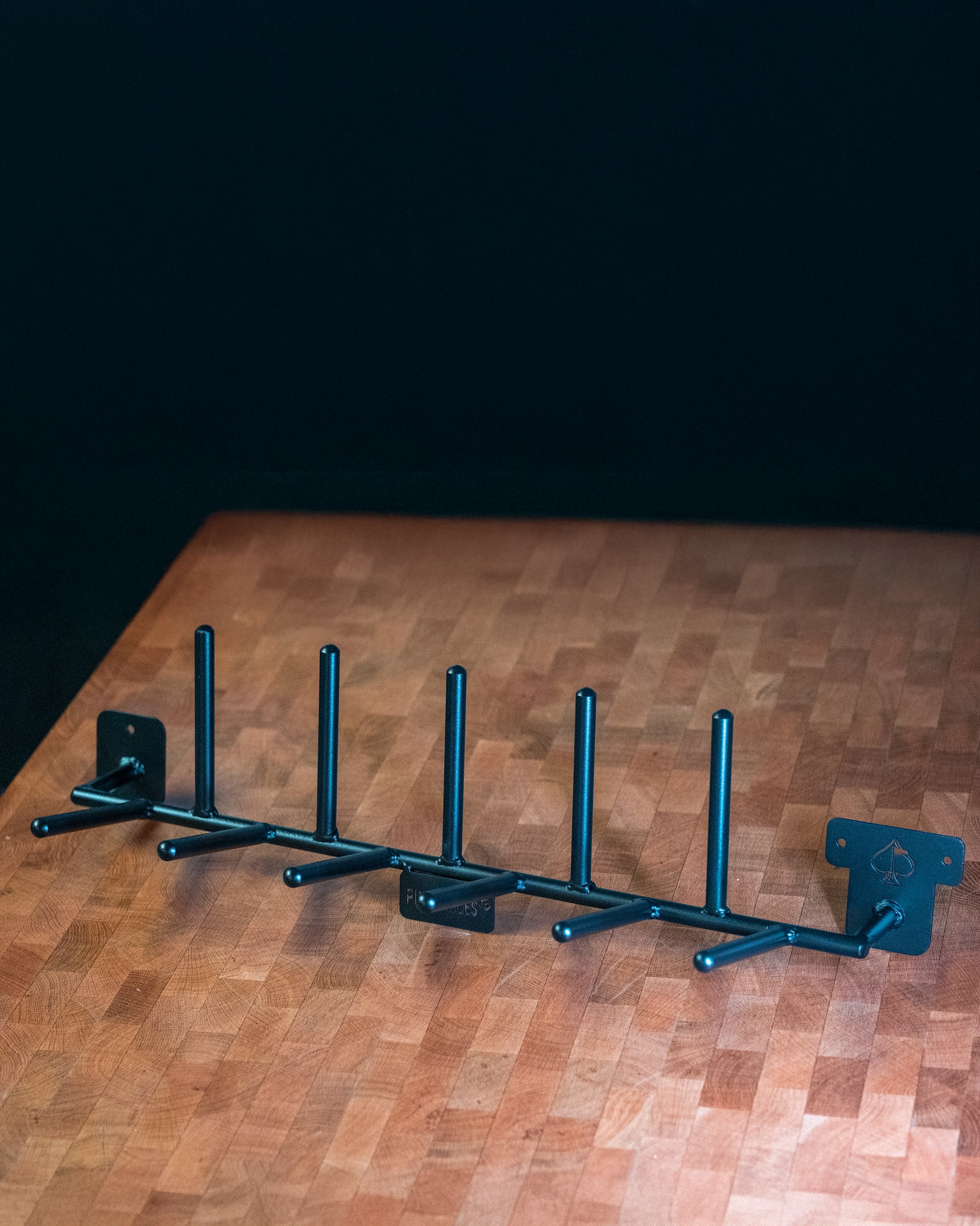 Compact Headcover Rack displayed on a wooden table, featuring a sleek design with multiple slots for organizing golf headcovers.