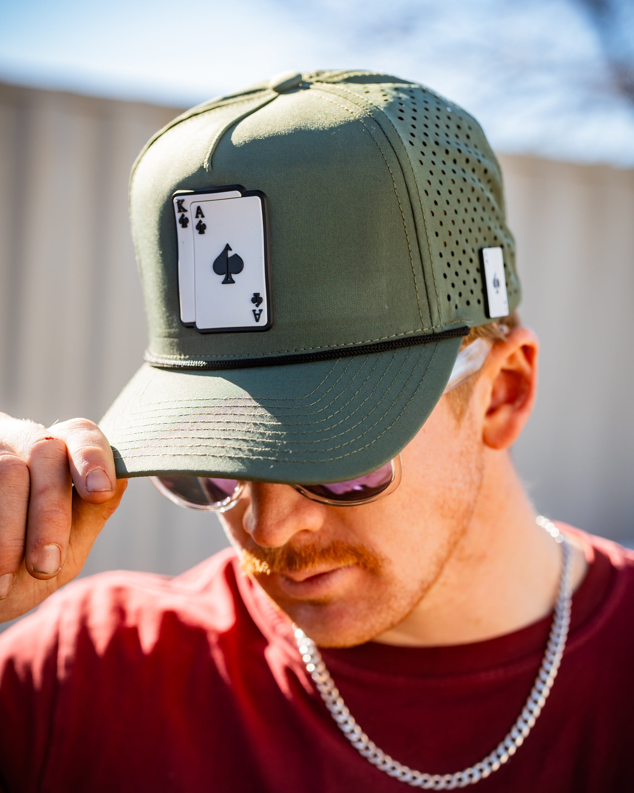 Perforated olive green rope hat with an embroidered AK logo.