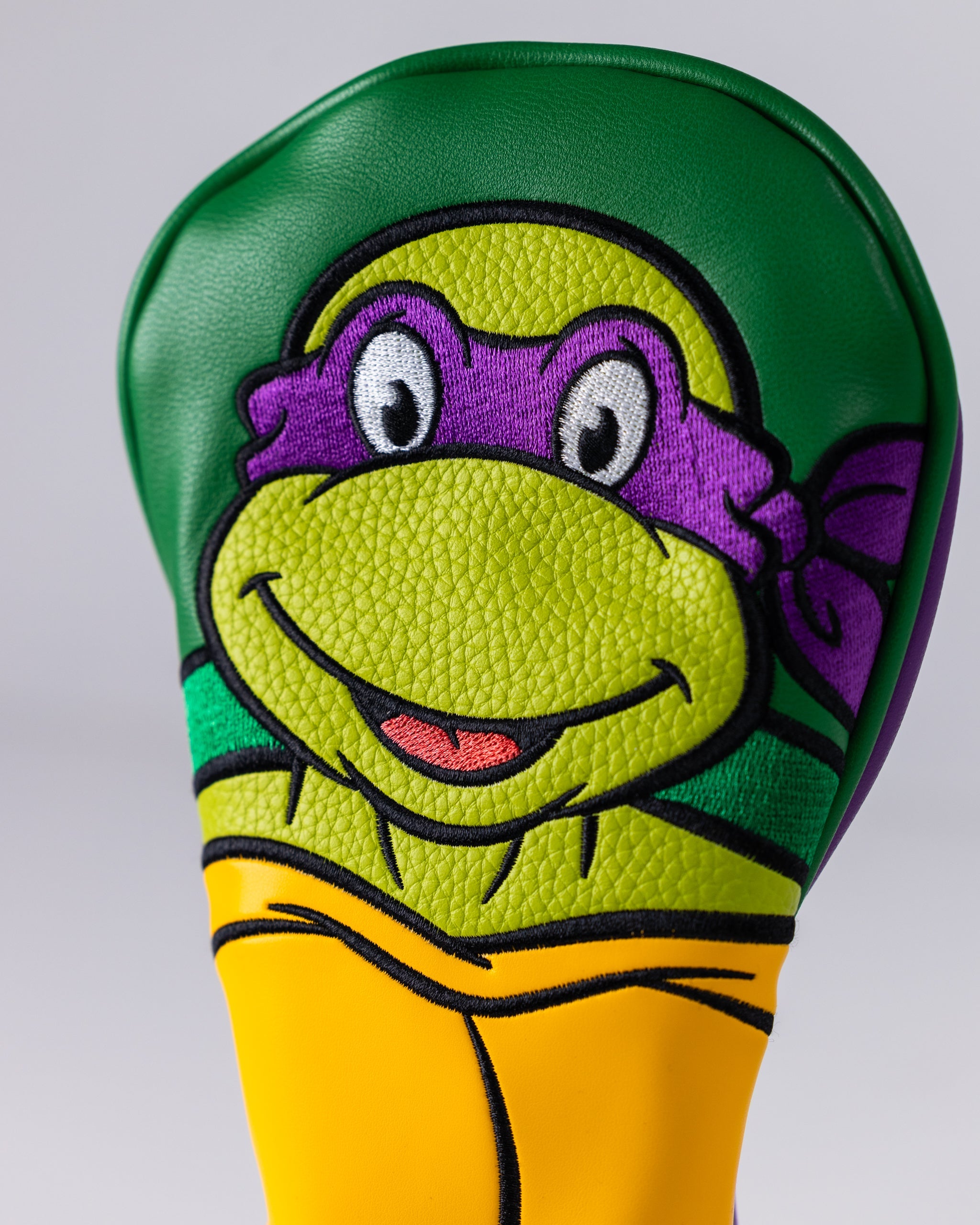TMNT Donatello Fairway Cover in purple with turtle design, featuring Donatello's signature weapon, a bo staff, for golf clubs.