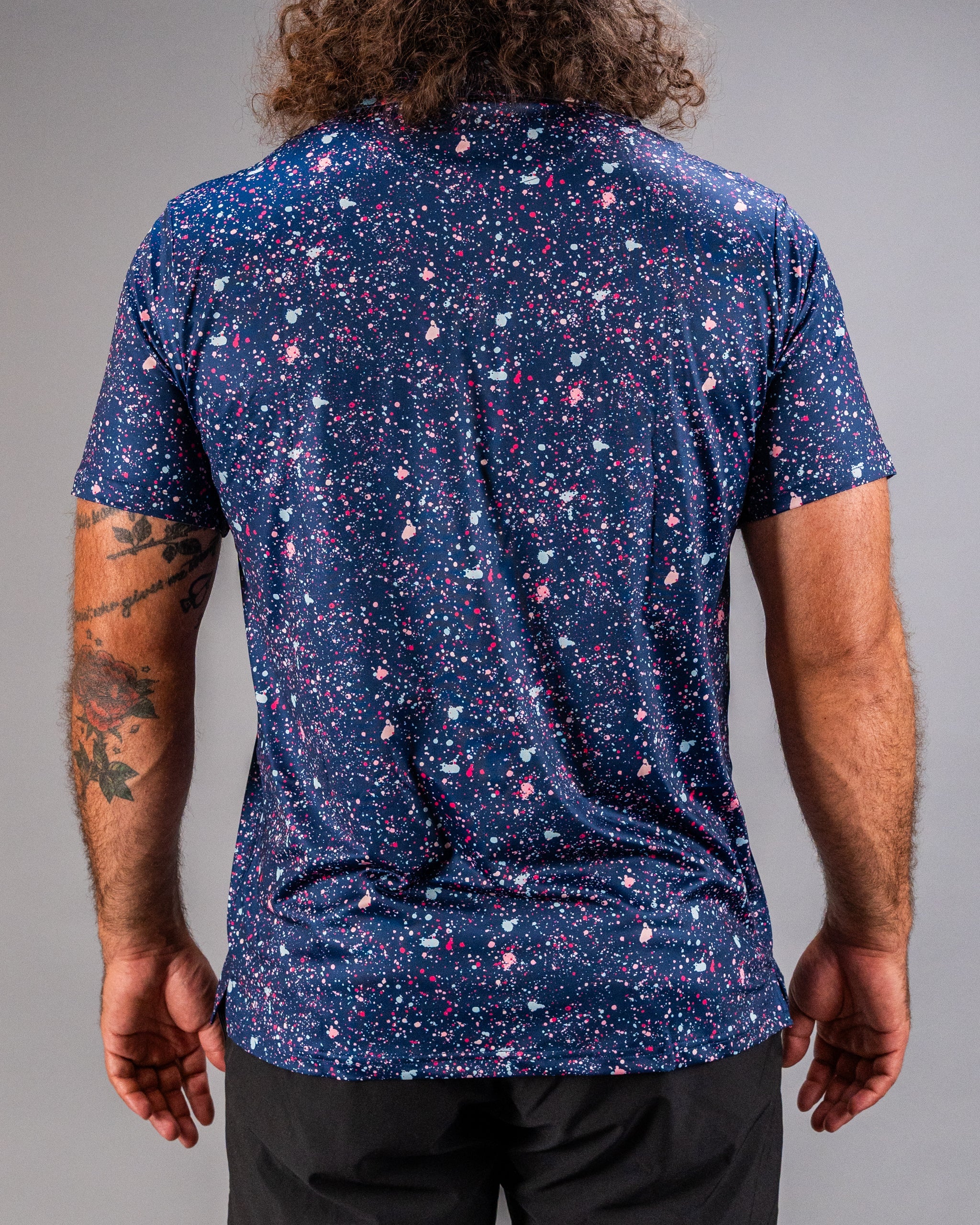 Men's blue splatter golf shirt featuring a vibrant, colorful pattern, perfect for making a statement on the course.