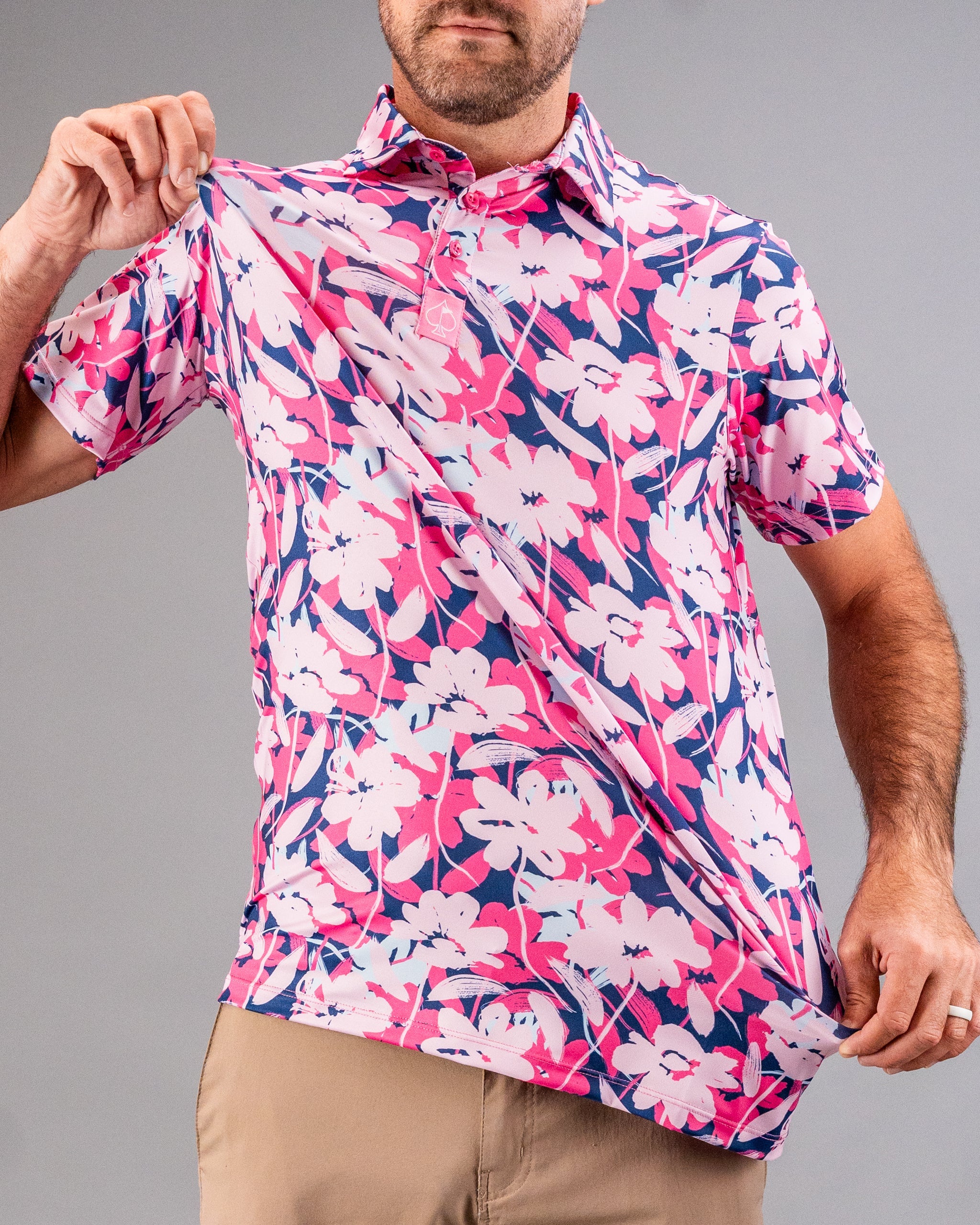 Bright pink, navy, and white floral golf shirt with a collar and short sleeves, perfect for bold golf style.