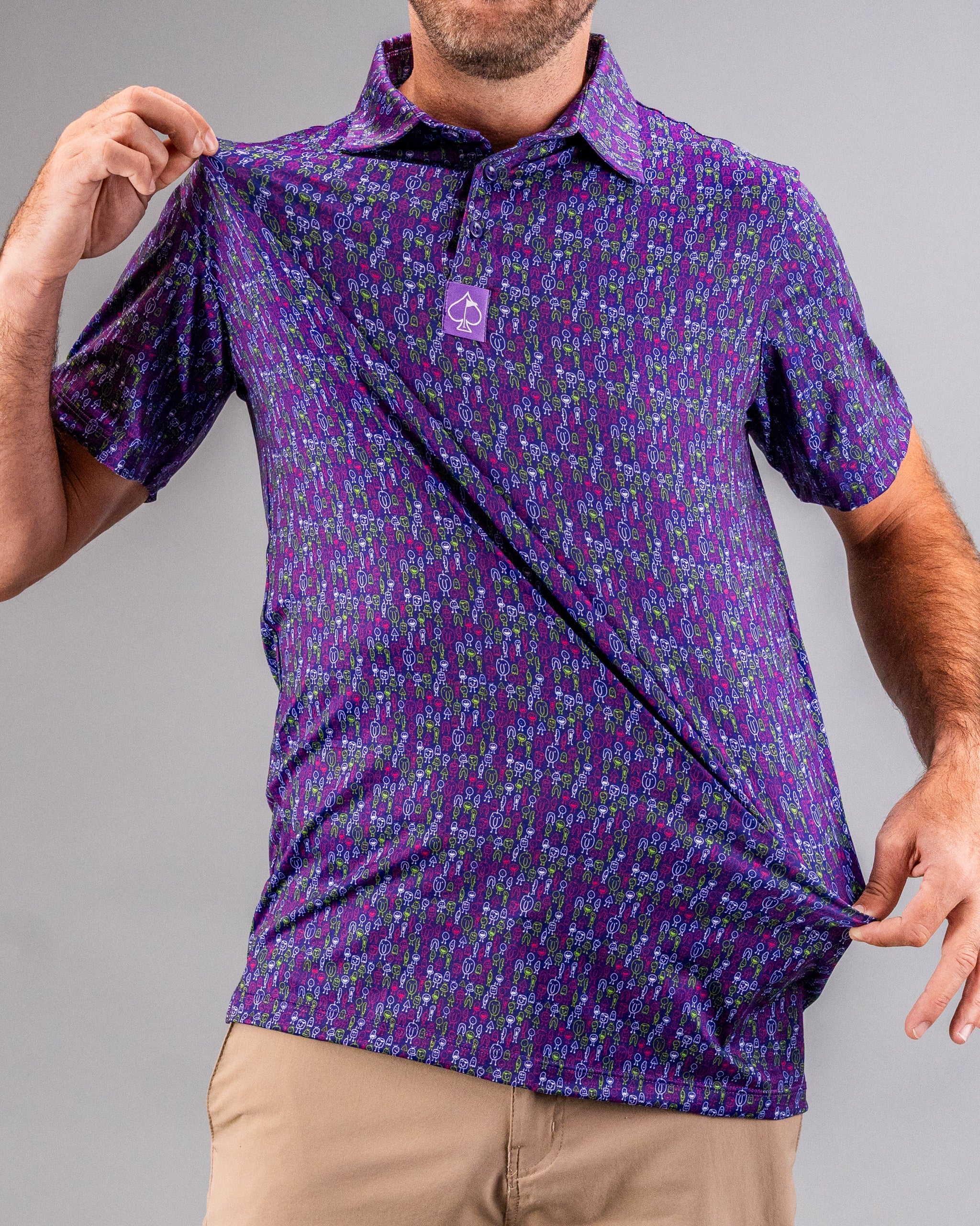 Man wearing a bold purple golf shirt with colorful, quirky golf club and ball pattern, with a small purple logo on the chest.