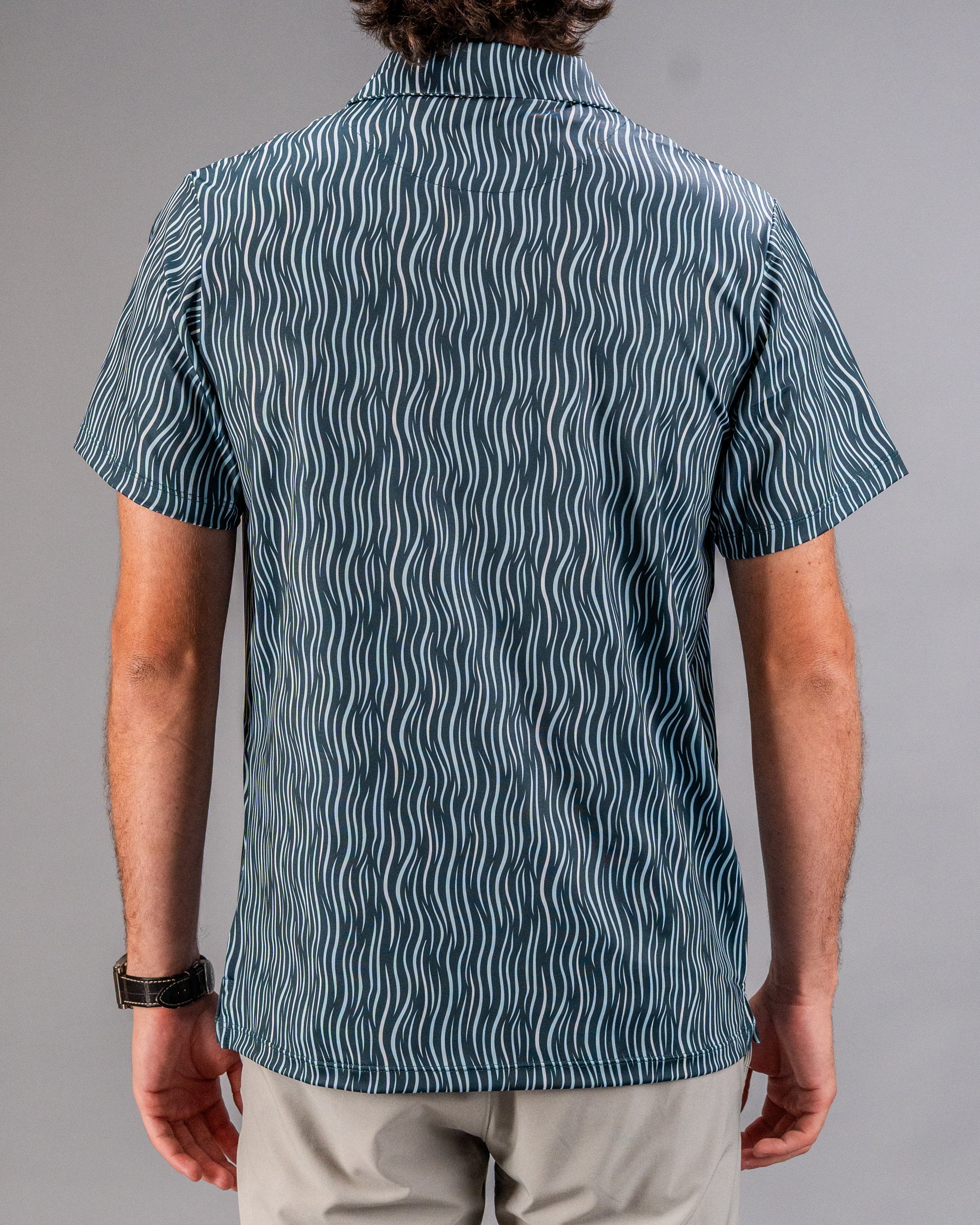 Bright blue and white patterned golf shirt with wavy lines, short sleeves, and a relaxed fit—perfect for bold golf style.