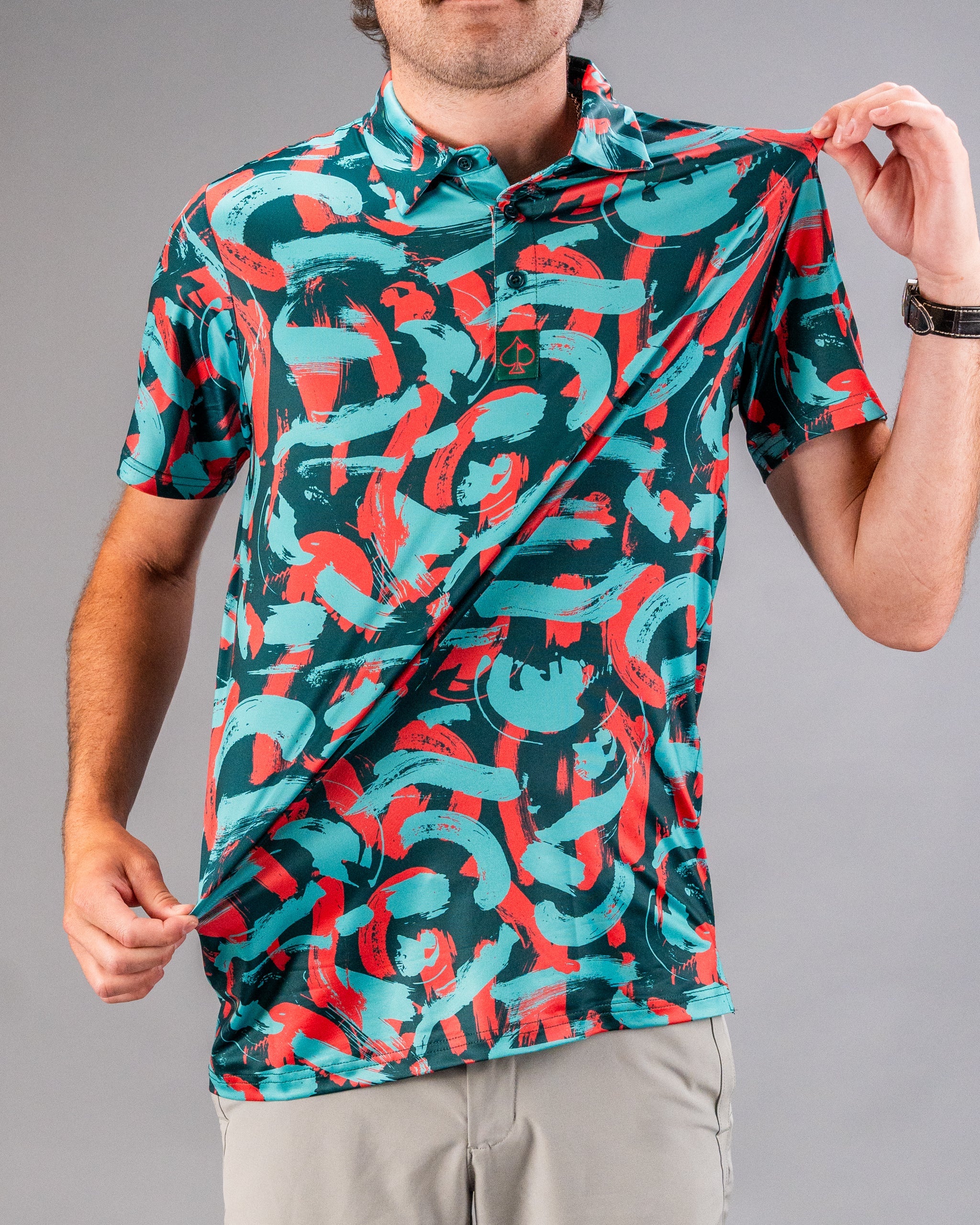Bold golf polo featuring a vibrant coral and teal paint stroke design, perfect for golfers looking to stand out on the course.