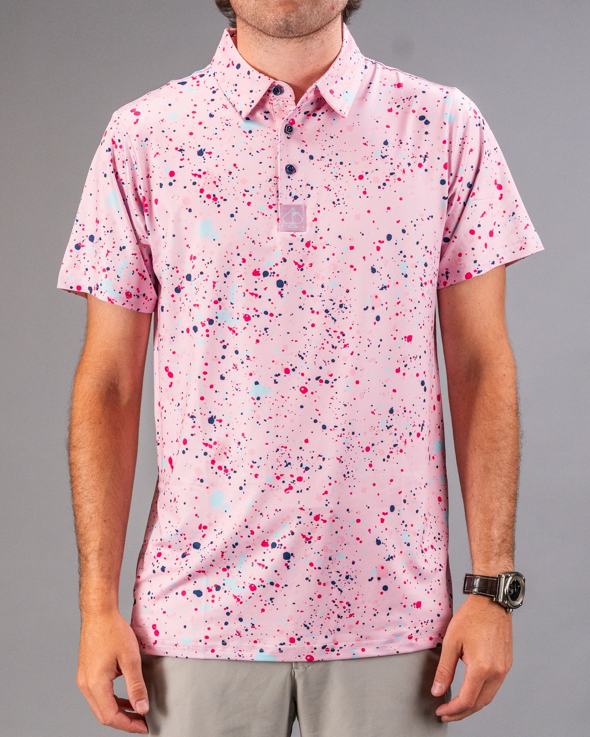 Men's pink golf polo shirt featuring a vibrant splatter pattern in various shades, perfect for making a bold statement on the course.