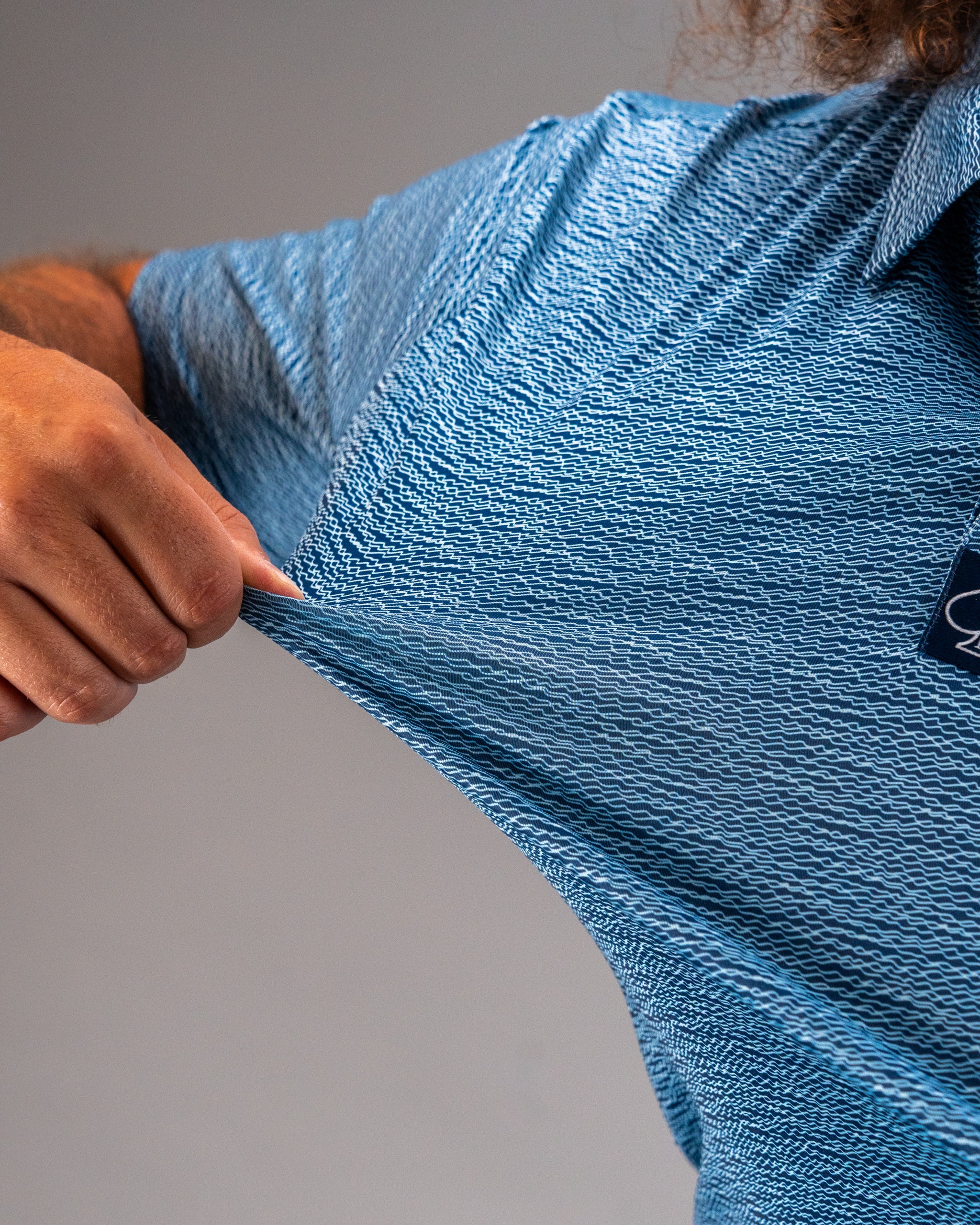 Men's Squiggle Blue golf polo featuring a textured pattern, showcasing its stretchable fabric and modern design.