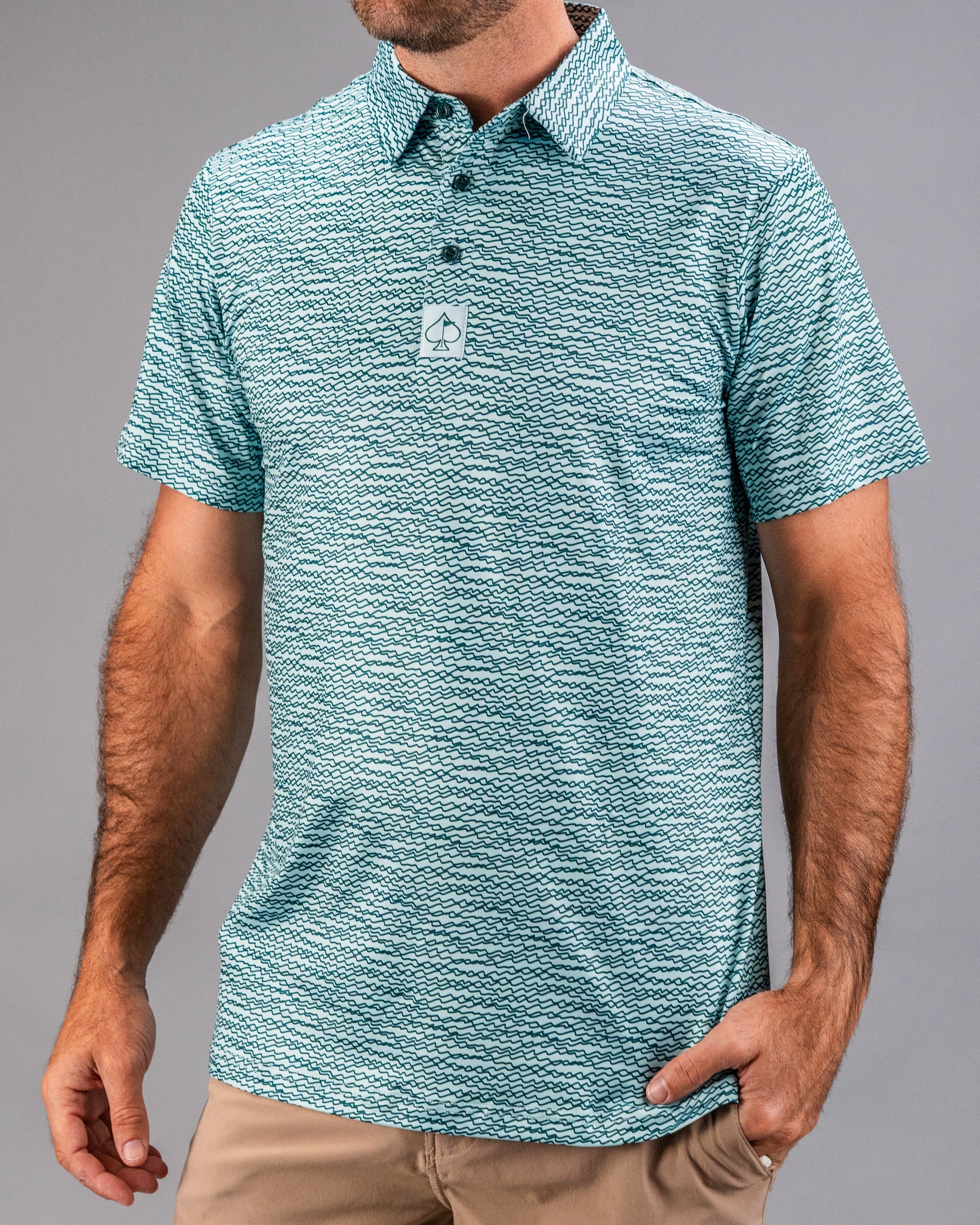 Men's teal golf polo shirt featuring a unique squiggle pattern, designed for style and comfort on the course.