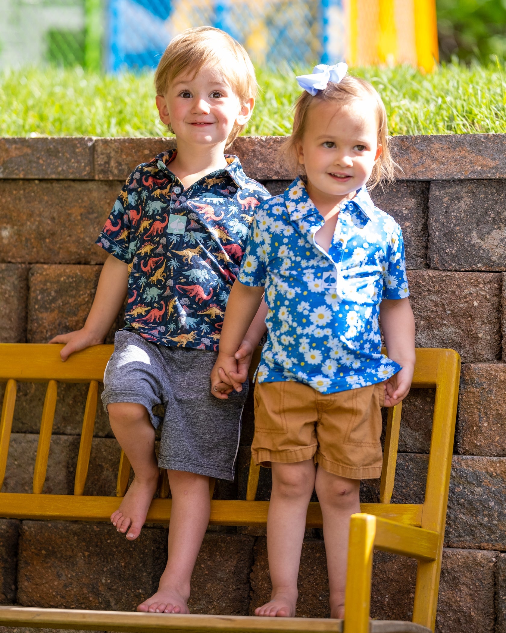 Youth Jurassic Polo in vibrant green featuring dinosaur print, set against a playful outdoor backdrop.