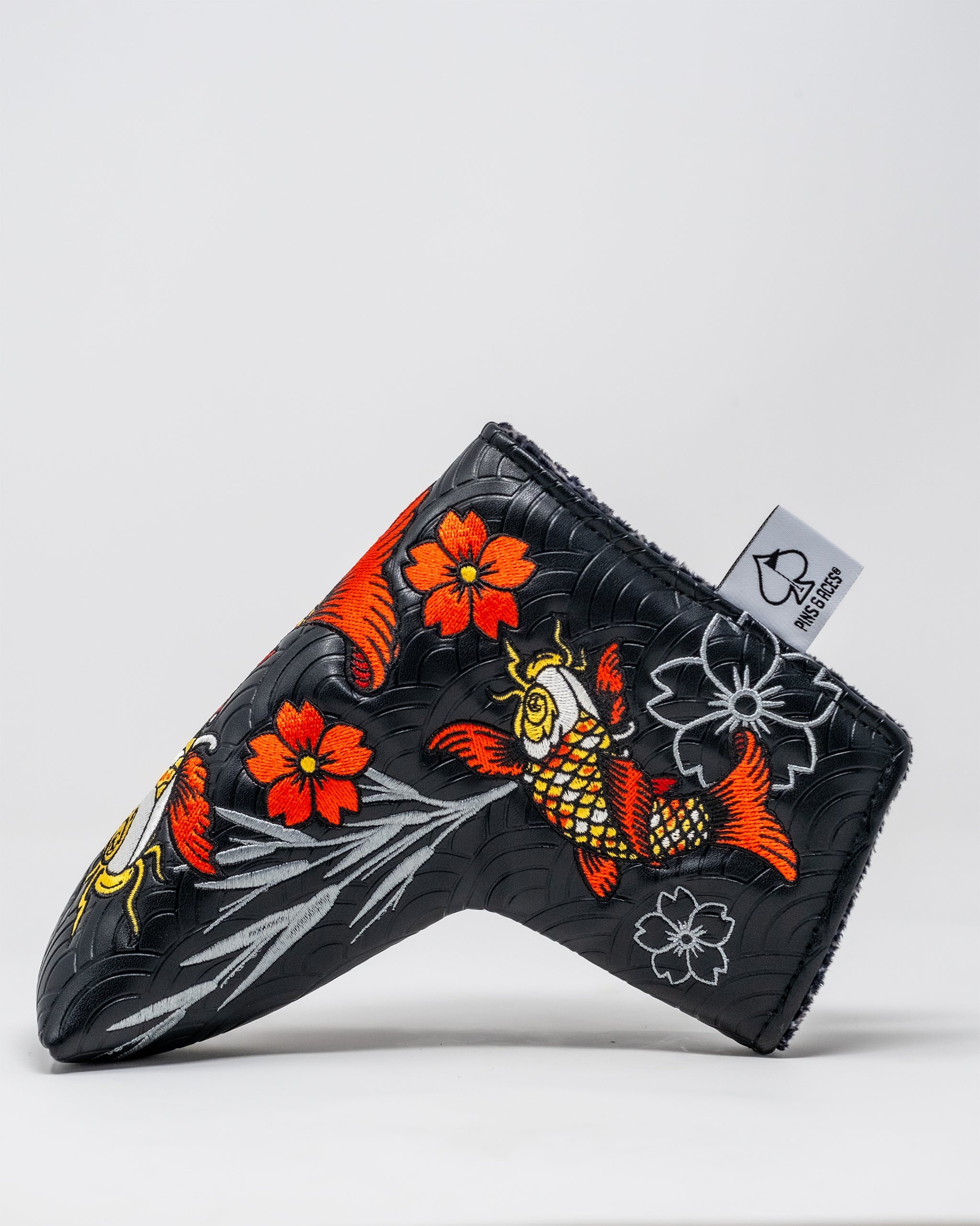 Koi Flow Blade Putter Cover featuring vibrant orange and blue wave patterns on a sleek design.