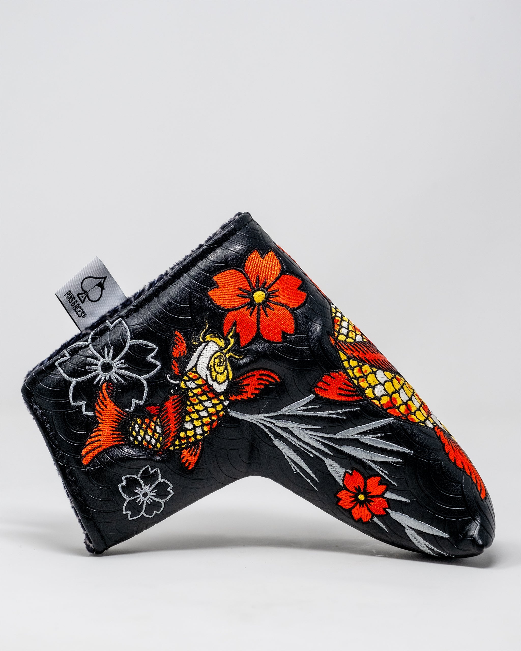 Koi Flow Blade Putter Cover featuring a vibrant fire wave design in shades of orange, red, and blue, tailored for standard blade putters.