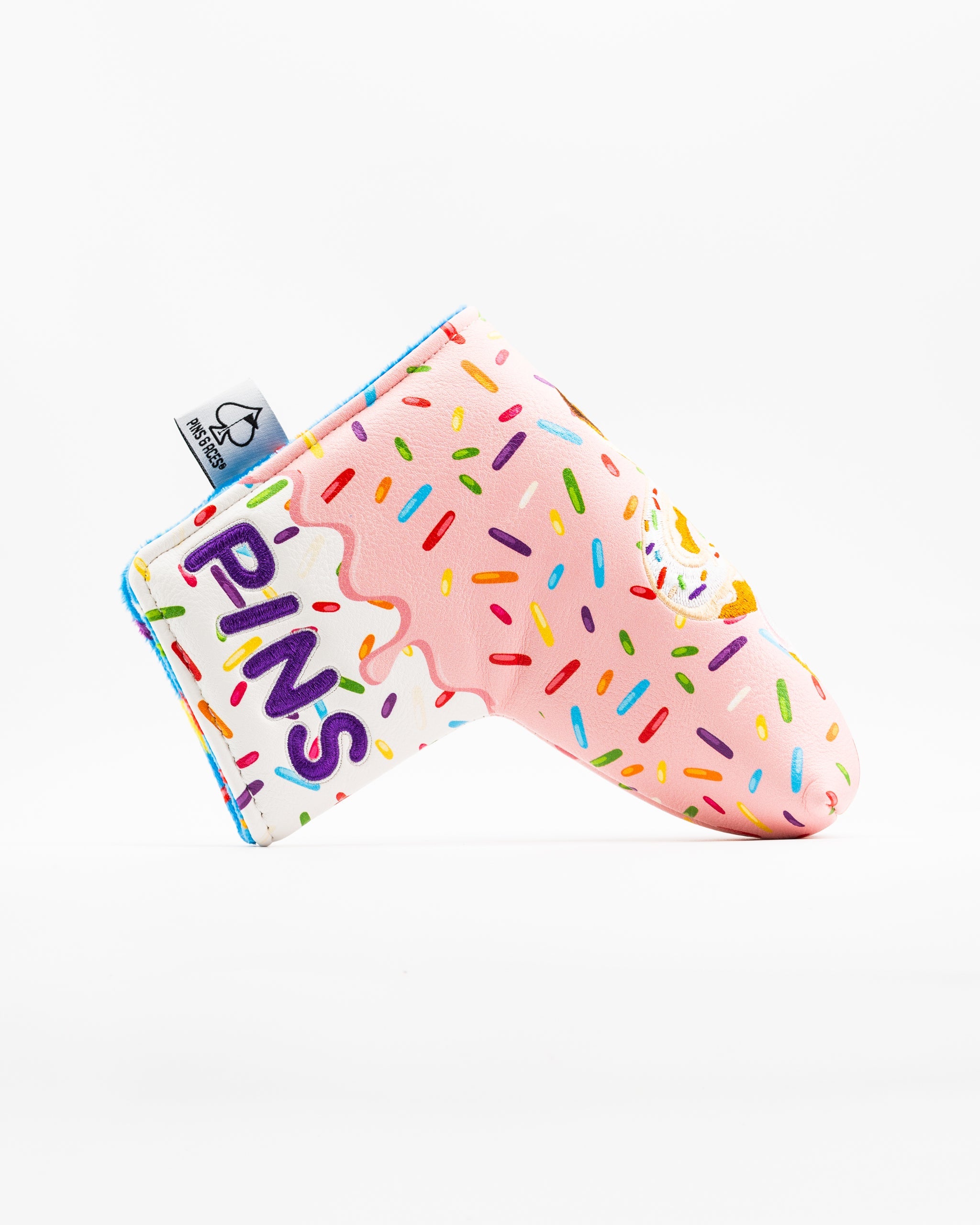 Colorful blade putter cover featuring a pink donut design with sprinkles and the word "PINS" prominently displayed.