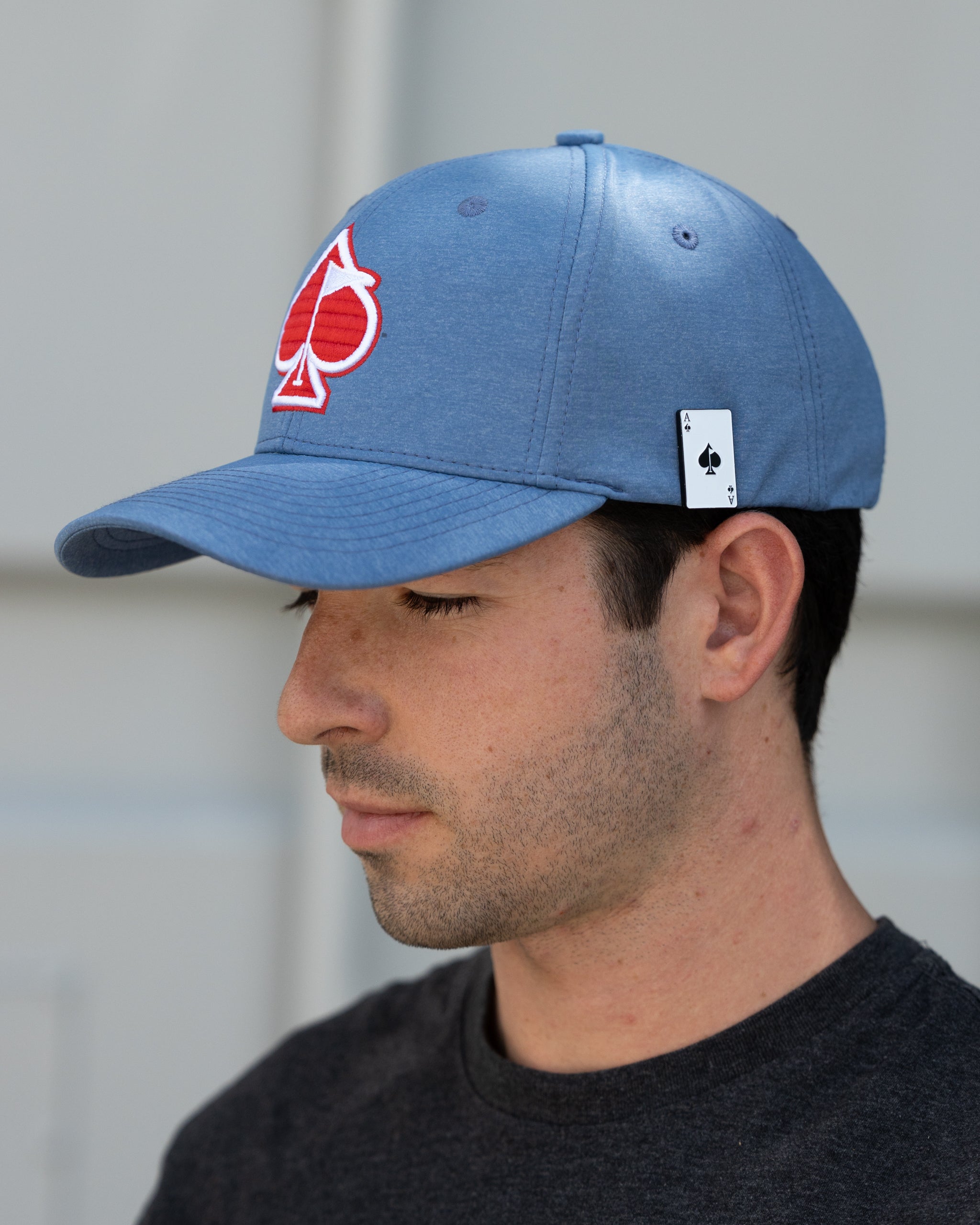 Blue Performance Spade Hat displayed outdoors, featuring a sleek design and adjustable strap for comfort.
