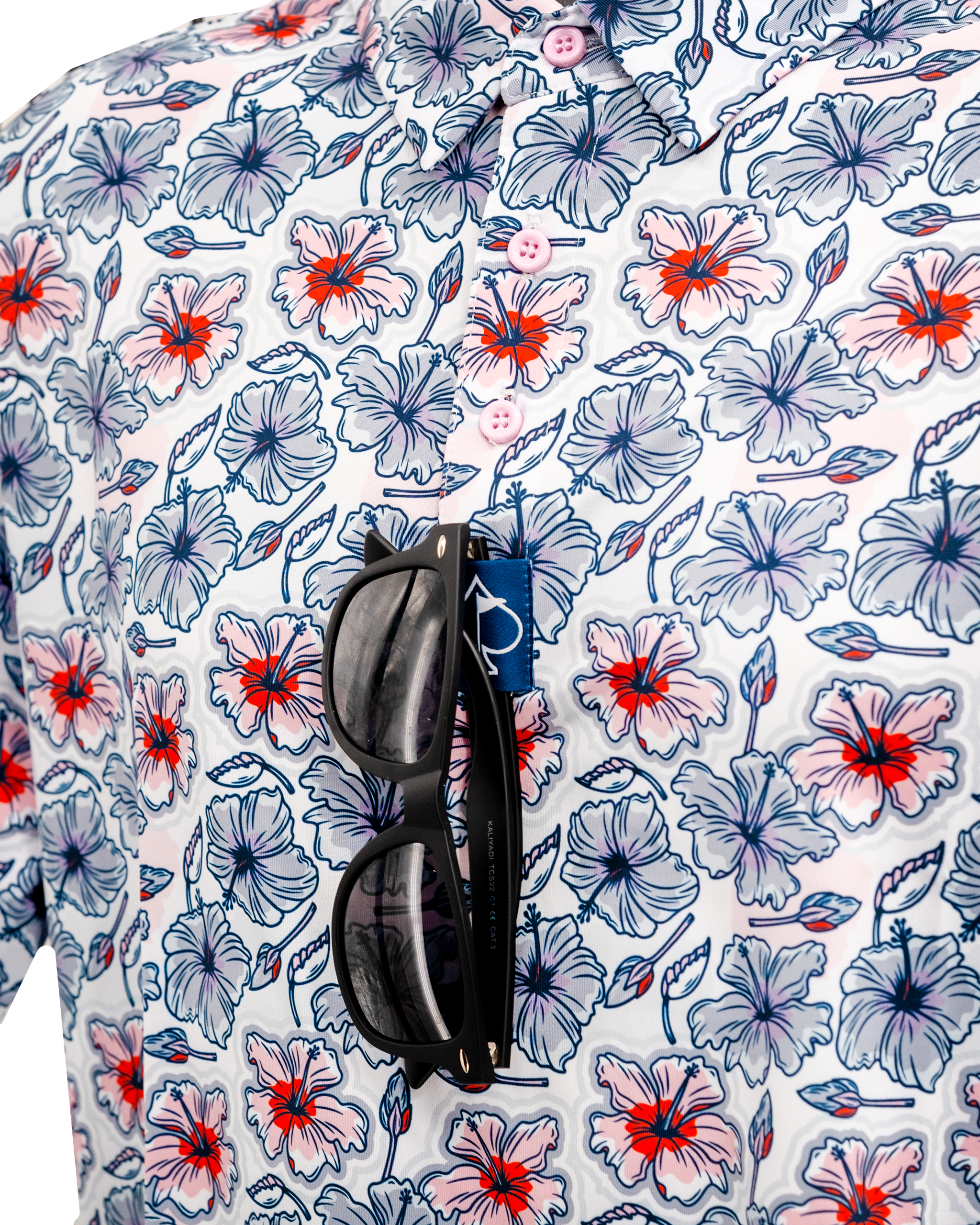 Colorful hibiscus-patterned shirt with sunglasses hanging from the collar, showcasing a vibrant tropical design.