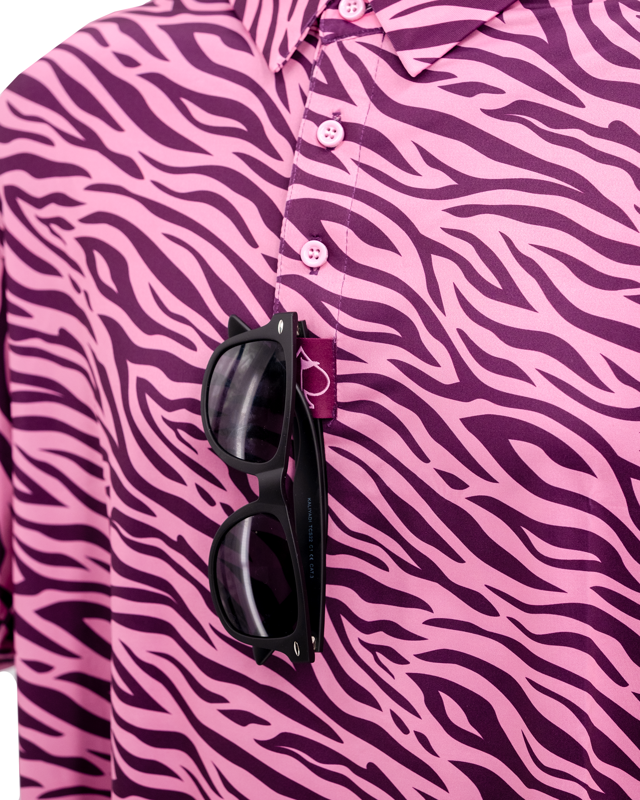 Violet Roar shirt featuring a bold pink and purple zebra print, with black sunglasses resting on the collar.