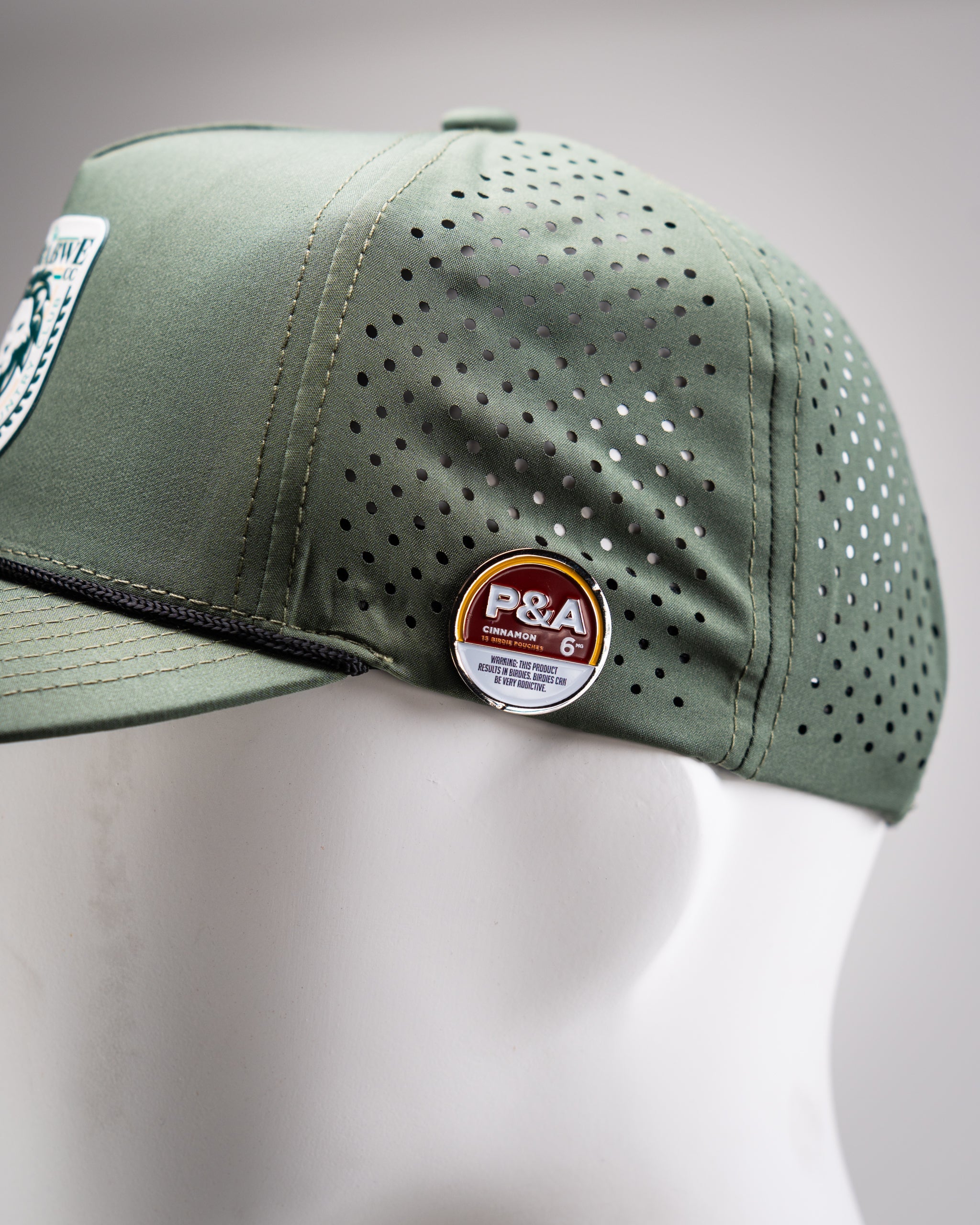 Perforated olive rope hat featuring Zynbabwe Country Club logo on front.