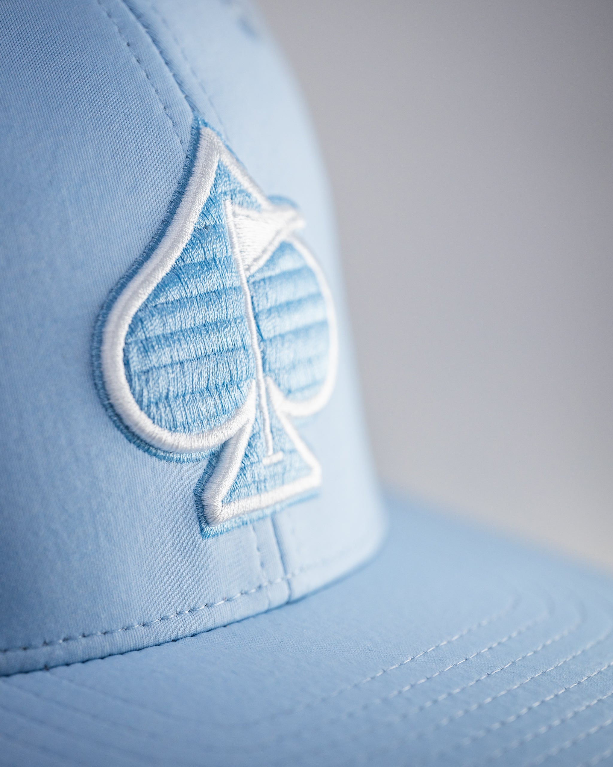 Performance Spade Hat in Carolina Blue, featuring a breathable material and adjustable strap.