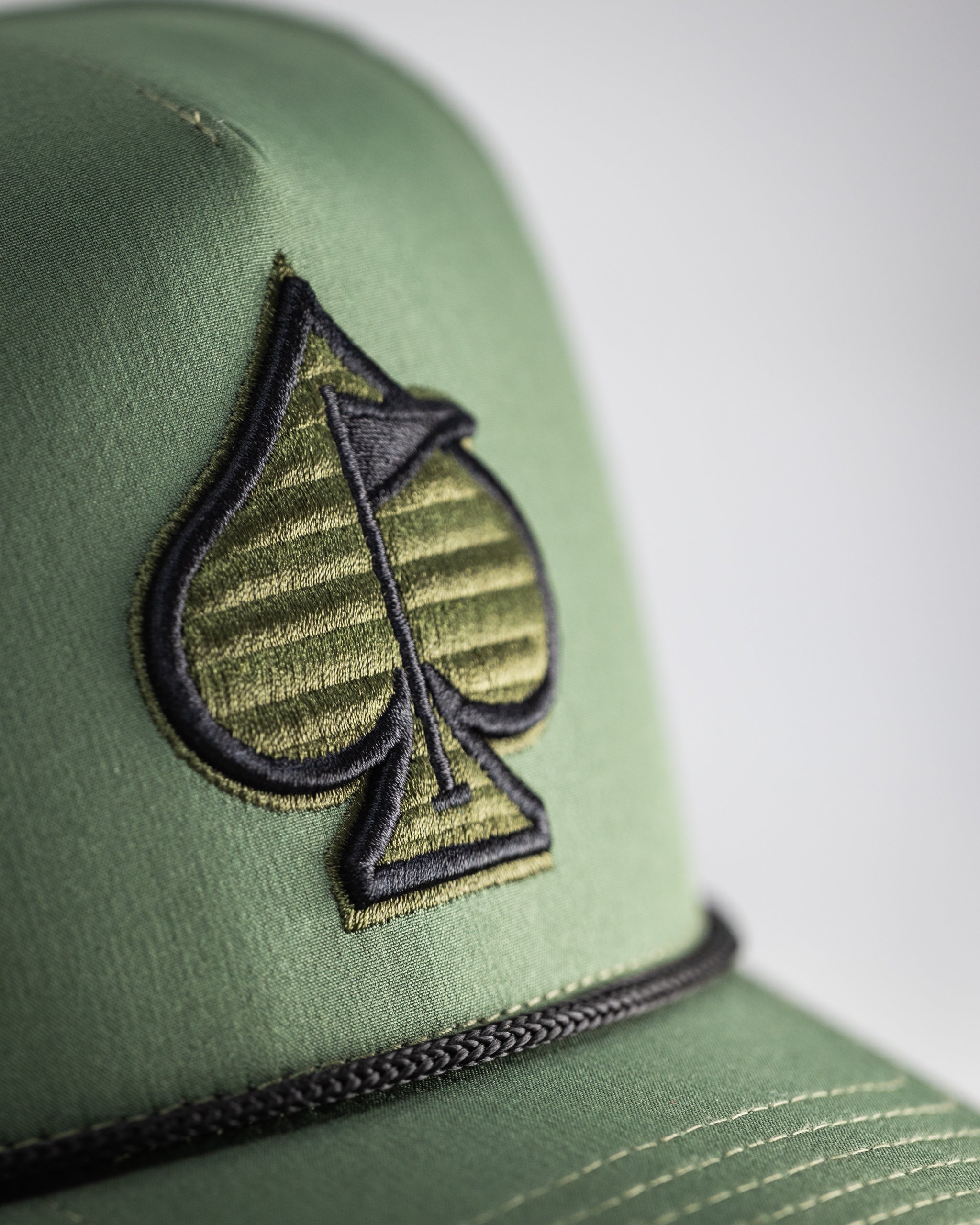 Perforated olive green rope hat with a wide brim and adjustable chin strap.