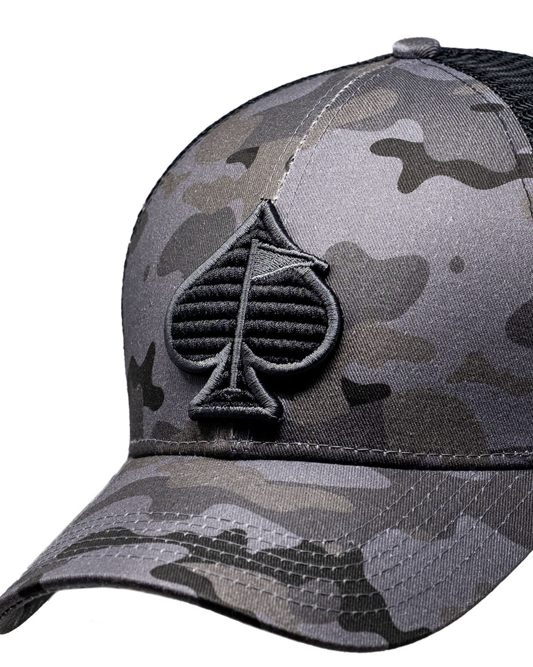 Urban camo trucker hat with mesh back and curved brim, featuring a spade logo on the front.