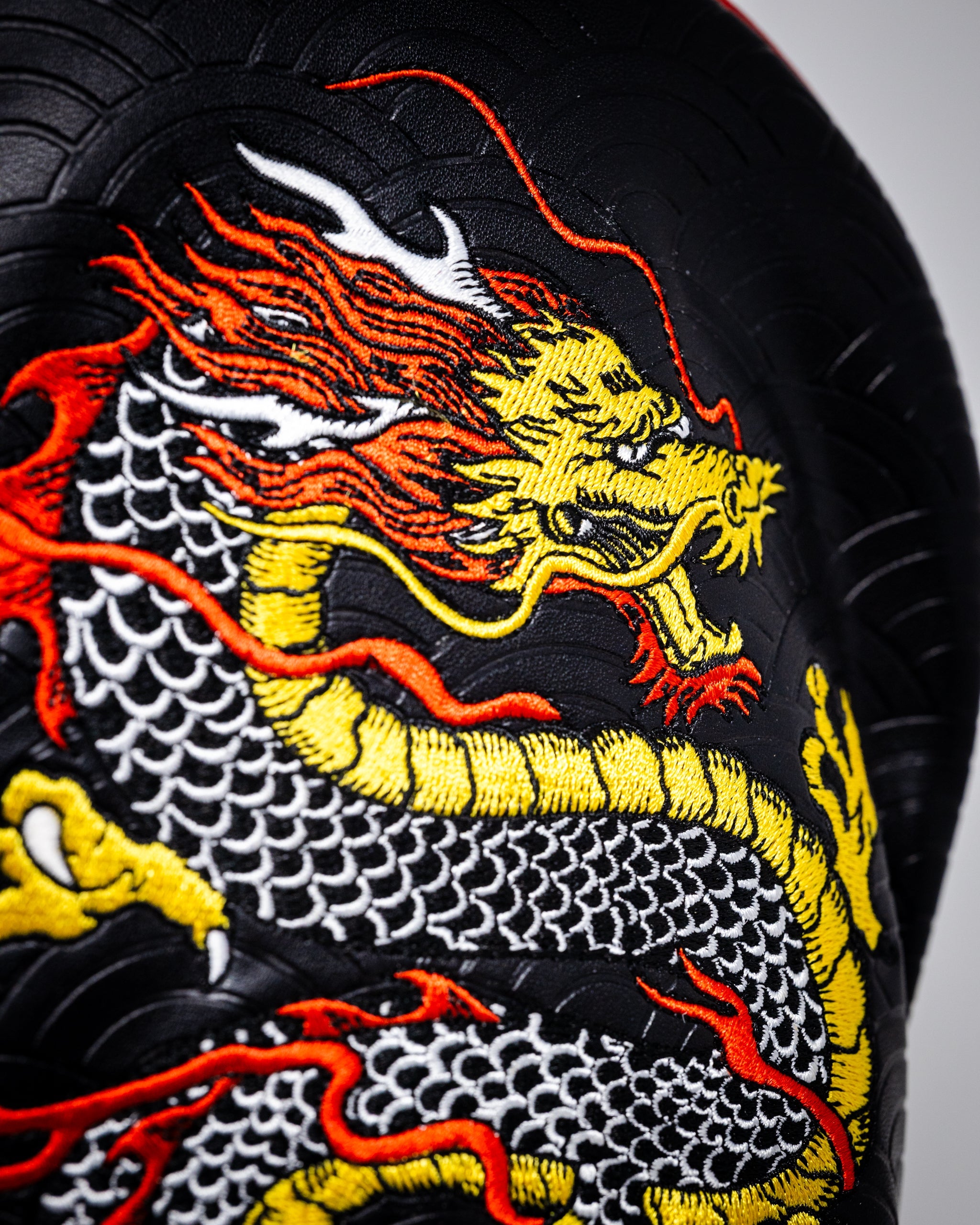 "Dragon's Dynasty Driver Cover featuring a vibrant dragon design on a black background."