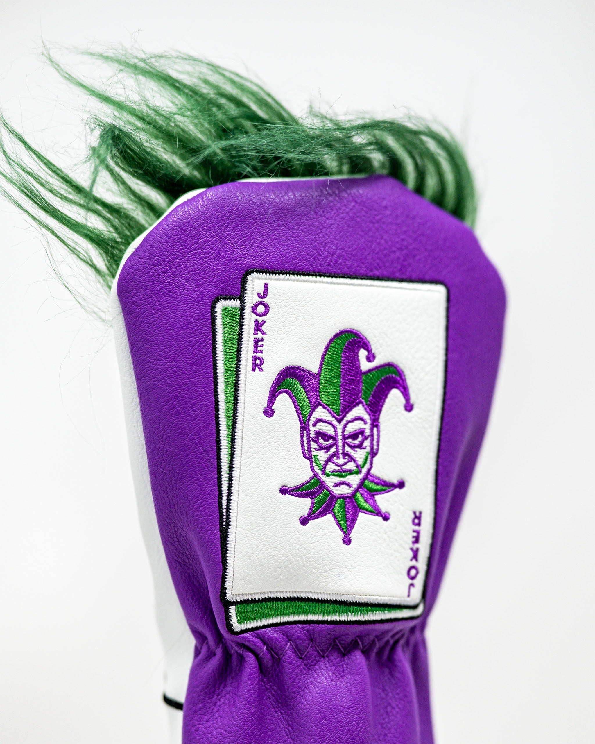 Purple golf headcover with green and purple jester face embroidery, bold design for standout golf style.
