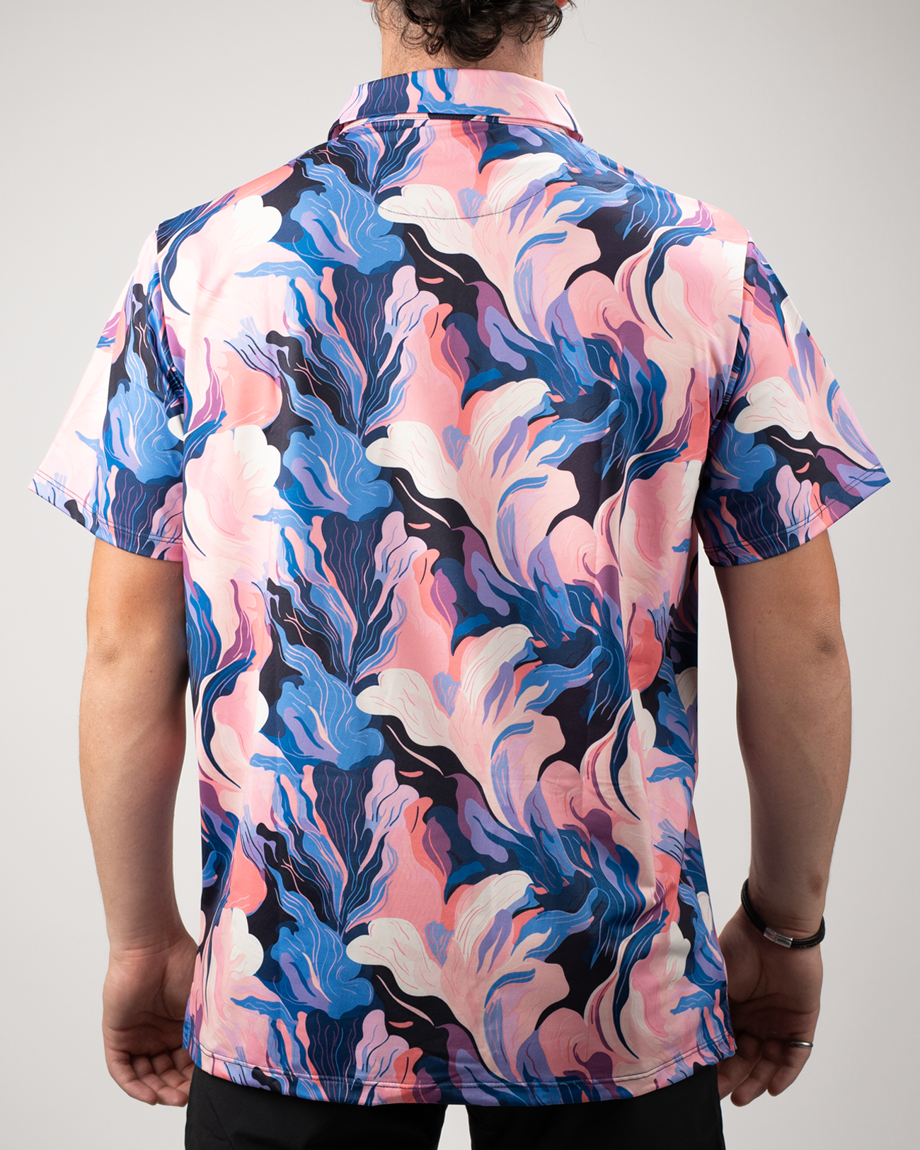 Men's short-sleeve golf shirt featuring a vibrant melting floral pattern in pink, blue, and white hues.
