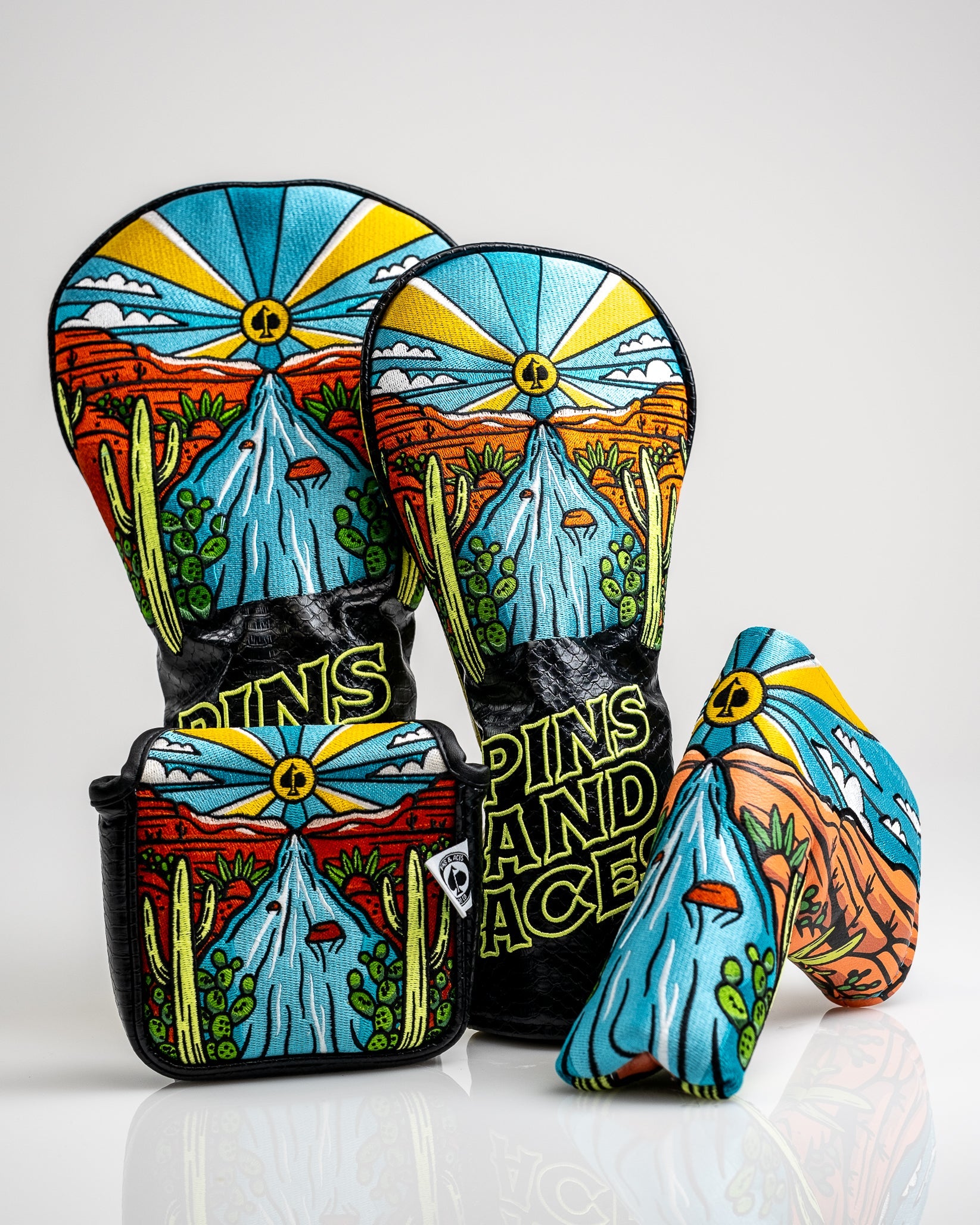 Colorful golf accessories featuring a desert landscape with cacti, mountains, and a bright sun, perfect for bold golf style.