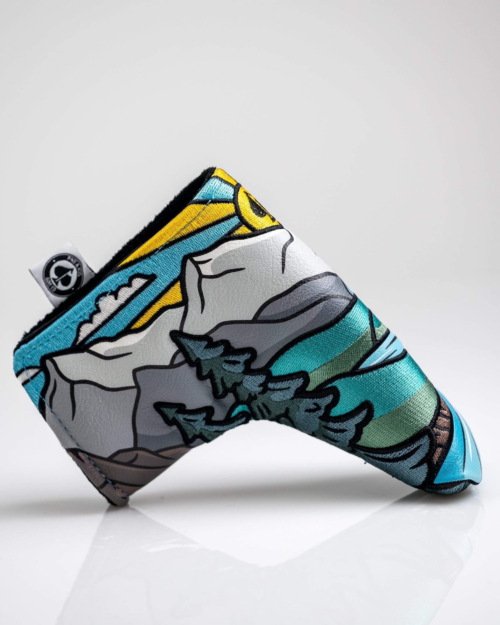 Colorful, mountain-themed golf headcover with vibrant blue, yellow, green, and black details for bold golf style.