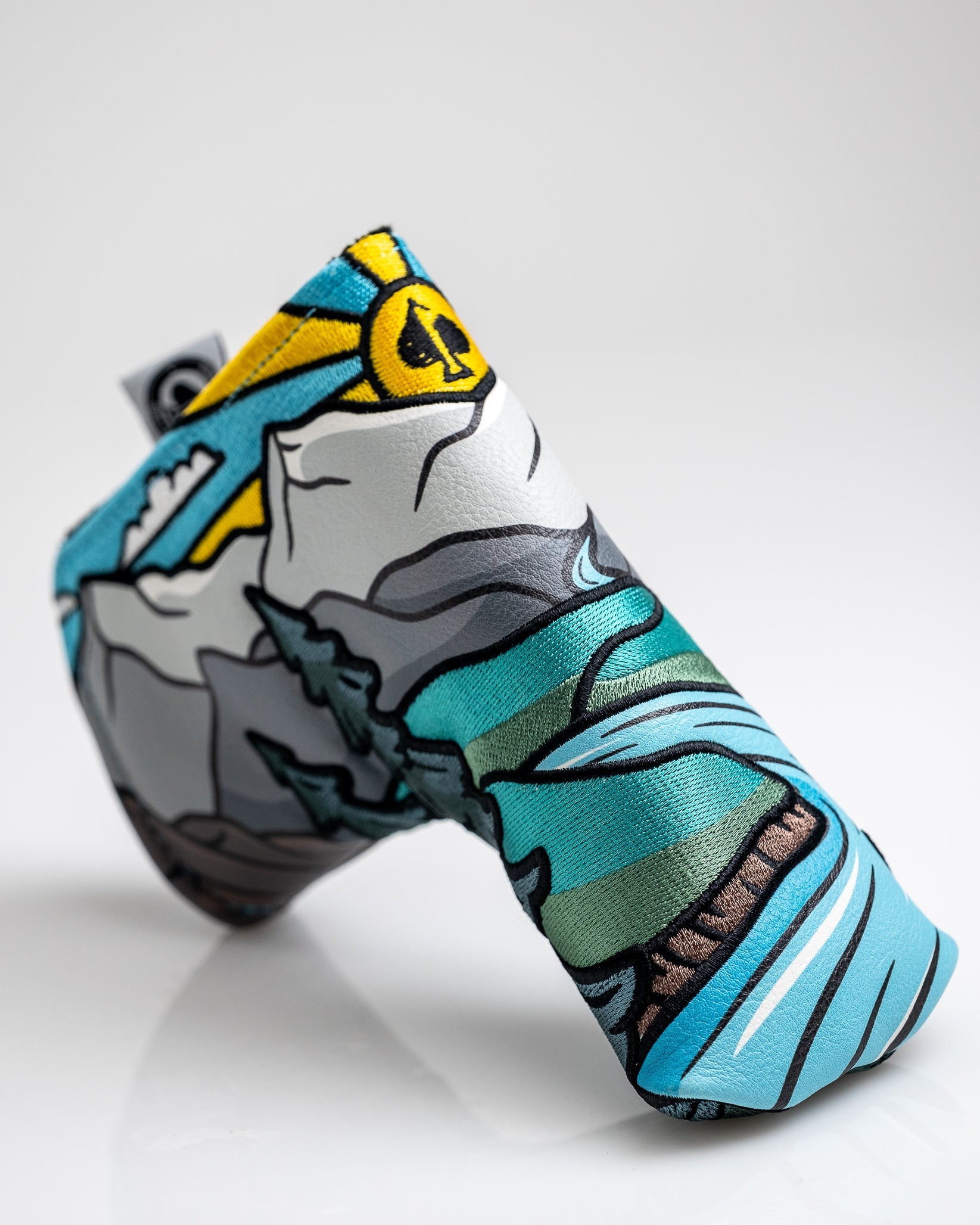 Colorful, bold golf headcover featuring a mountain landscape with blue, green, yellow, and black accents, perfect for stan...
