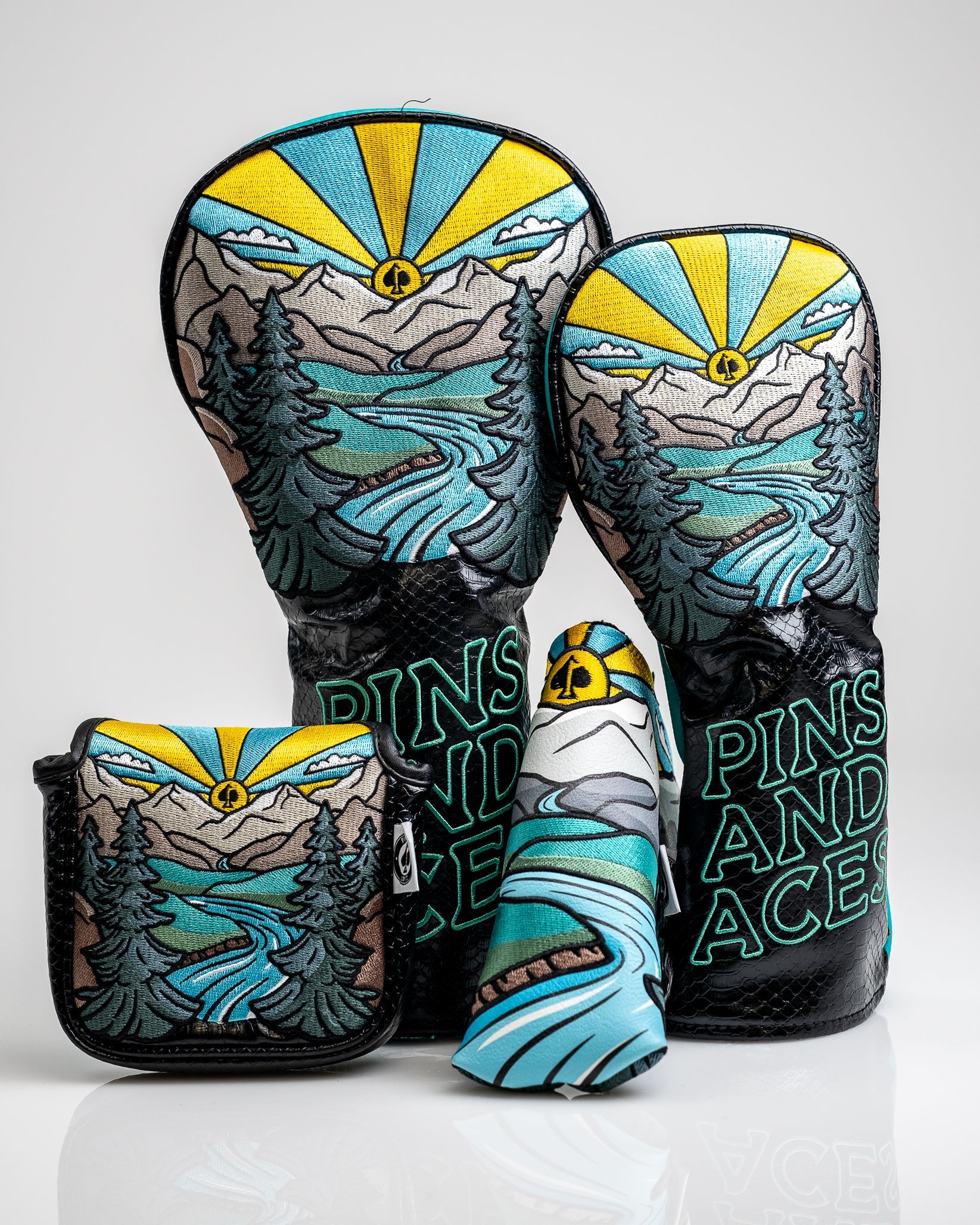Bold mountain and river golf accessories set with black accents, featuring vibrant blue, yellow, and gray colors.