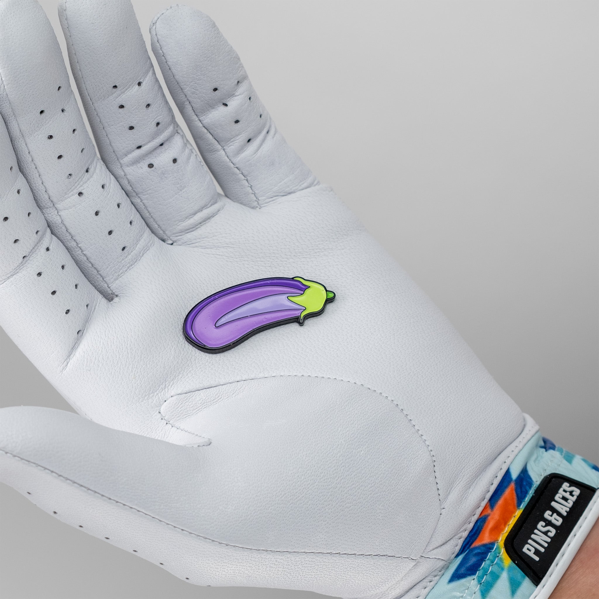 Eggplant-shaped ball marker for golf, featuring a vibrant purple color and detailed design.