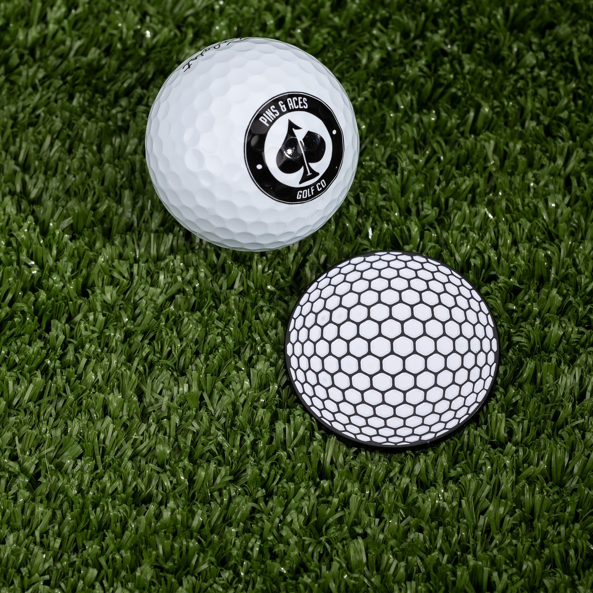 Golf ball ball marker featuring a sleek design, placed next to a golf ball on a green background.