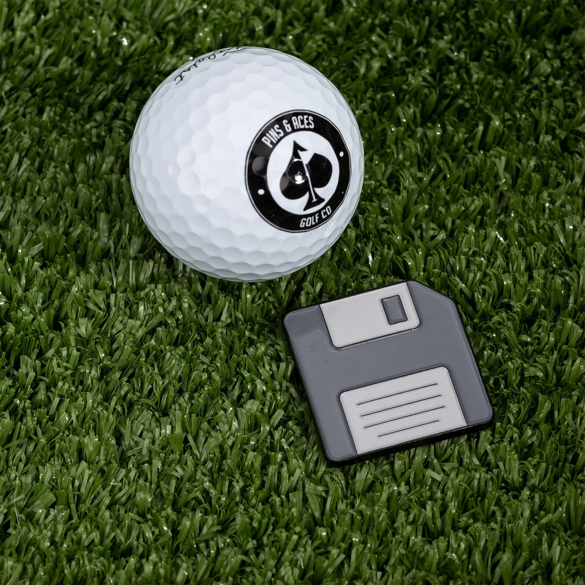 Floppy disc-shaped ball marker featuring vibrant colors and a retro design, ideal for golfers.