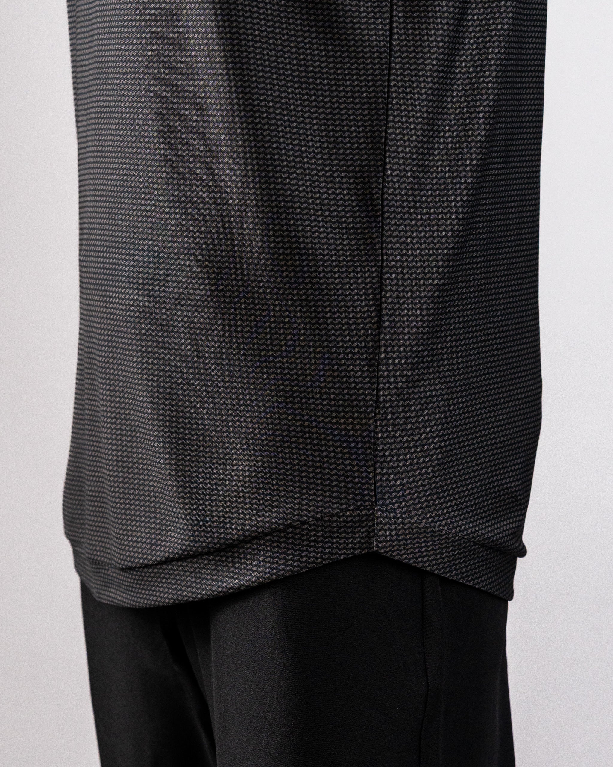 Close-up of a black Player Preferred™ Polo Night Wave with a subtle zigzag pattern, paired with black pants.