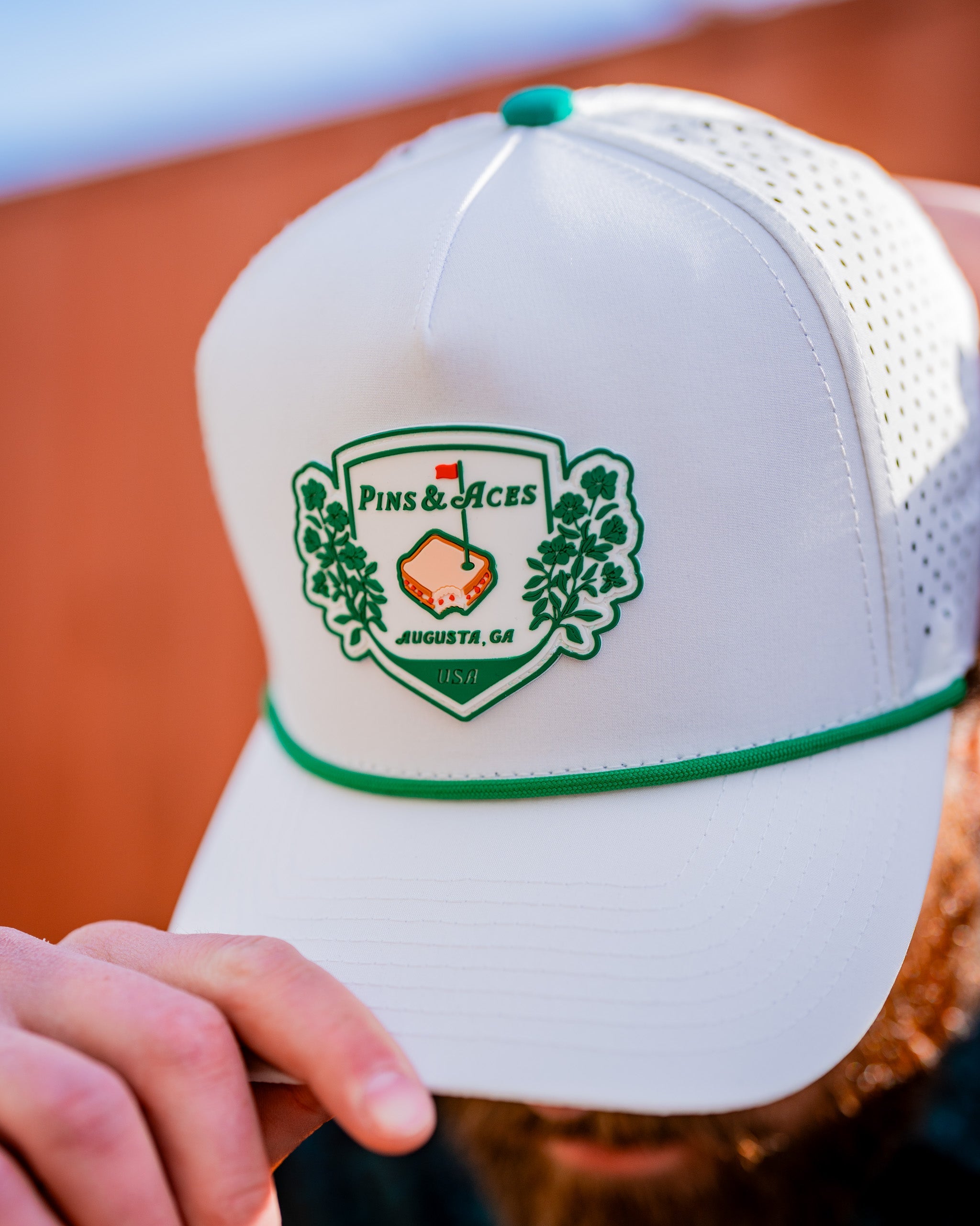 White perforated rope hat featuring the Pimento Crest logo.