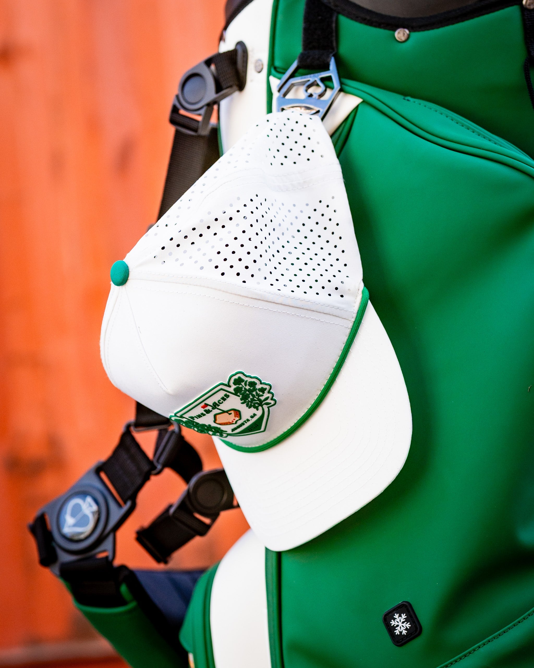 Alt text: White perforated rope hat with Pimento Crest logo, showcasing a stylish design.